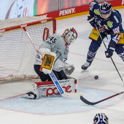 Haie-Backup Tobias Ancicka (l) und Kapitän Moritz Müller verteidigen das Tor gegen Berlins Lean Bergmann (M).