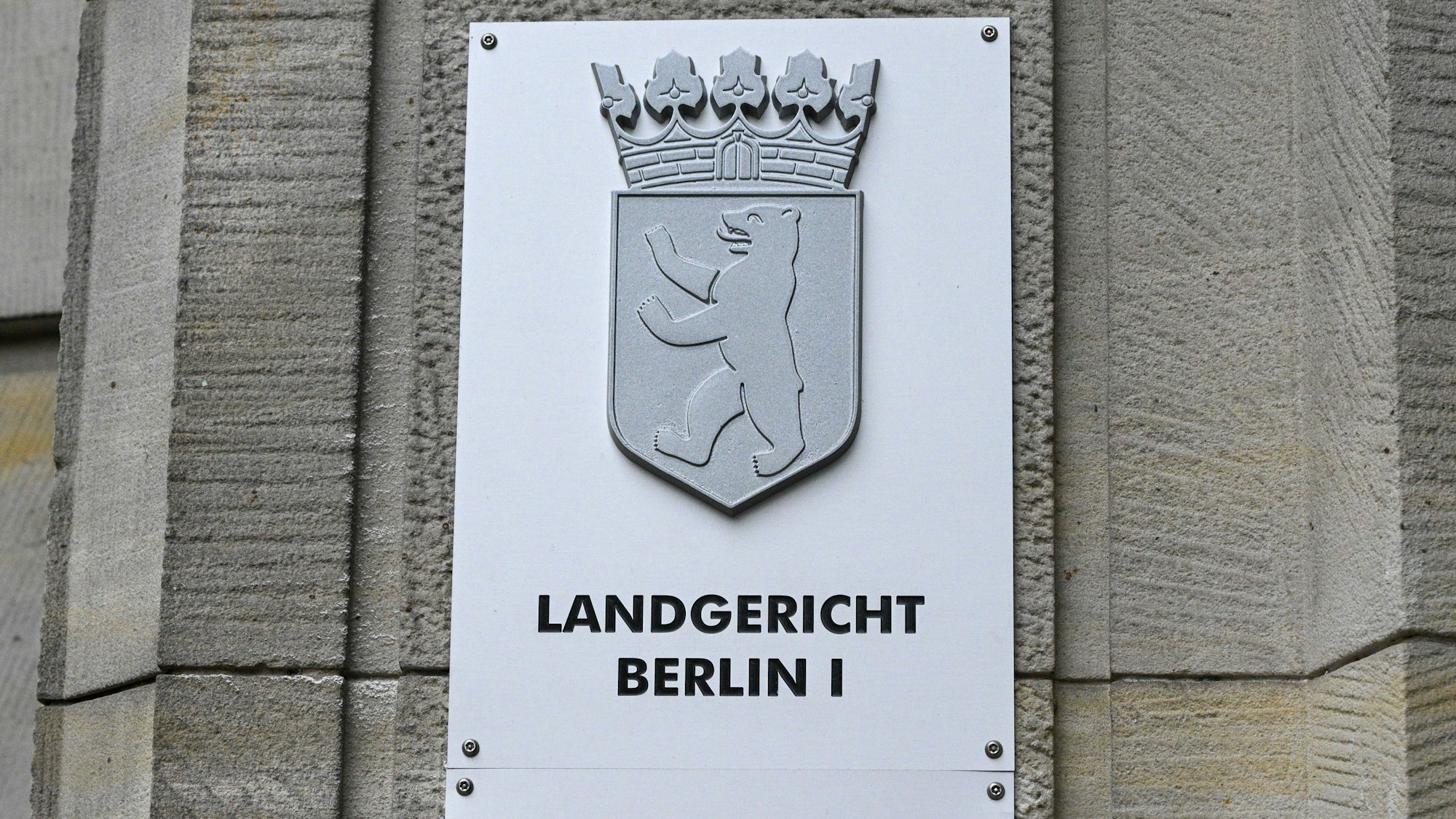 ARCHIV - 03.06.2024, Berlin: Ein Schild weist auf das Landgericht Berlin an der Fassade zum Kriminalgericht Moabit in der Turmstraße hin. Nach einem Angriff auf eine Frau mit einem Hackmesser steht ein 32-Jähriger vor Gericht. Auch ihr einjähriger Sohn habe Schnittwunden erlitten. (zu dpa: «Tochter im Netz zum Missbrauch angeboten: Vater vor Gericht») Foto: Jens Kalaene/dpa +++ dpa-Bildfunk +++