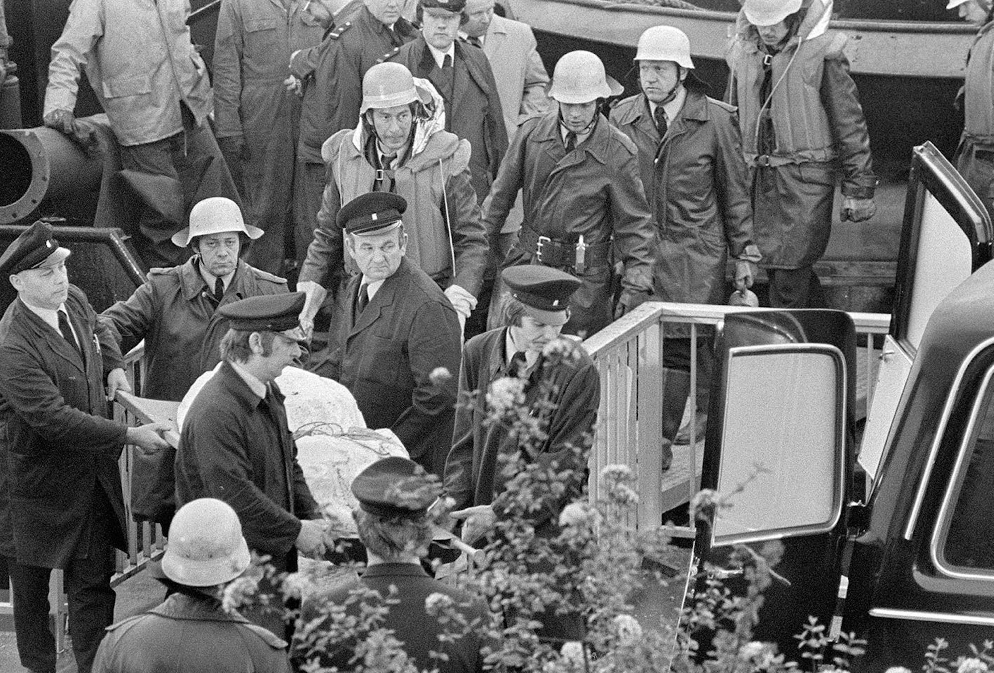 Betroffene Mienen bei den Feuerwehrmännern und Bestattern, die die Opfer des Brandes aus dem Wrack der „Prinses Irene“ holen.