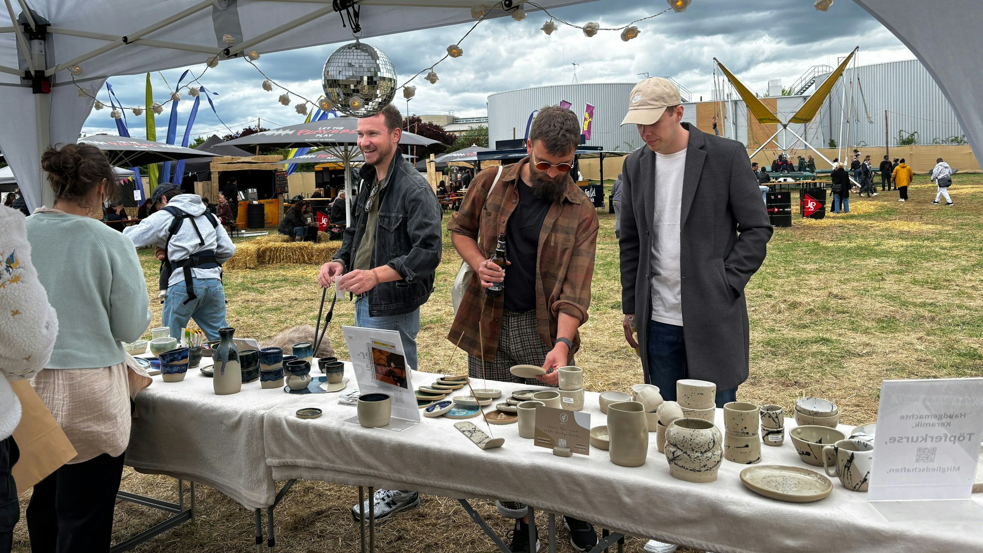 Besucher an einem Keramik-Stand