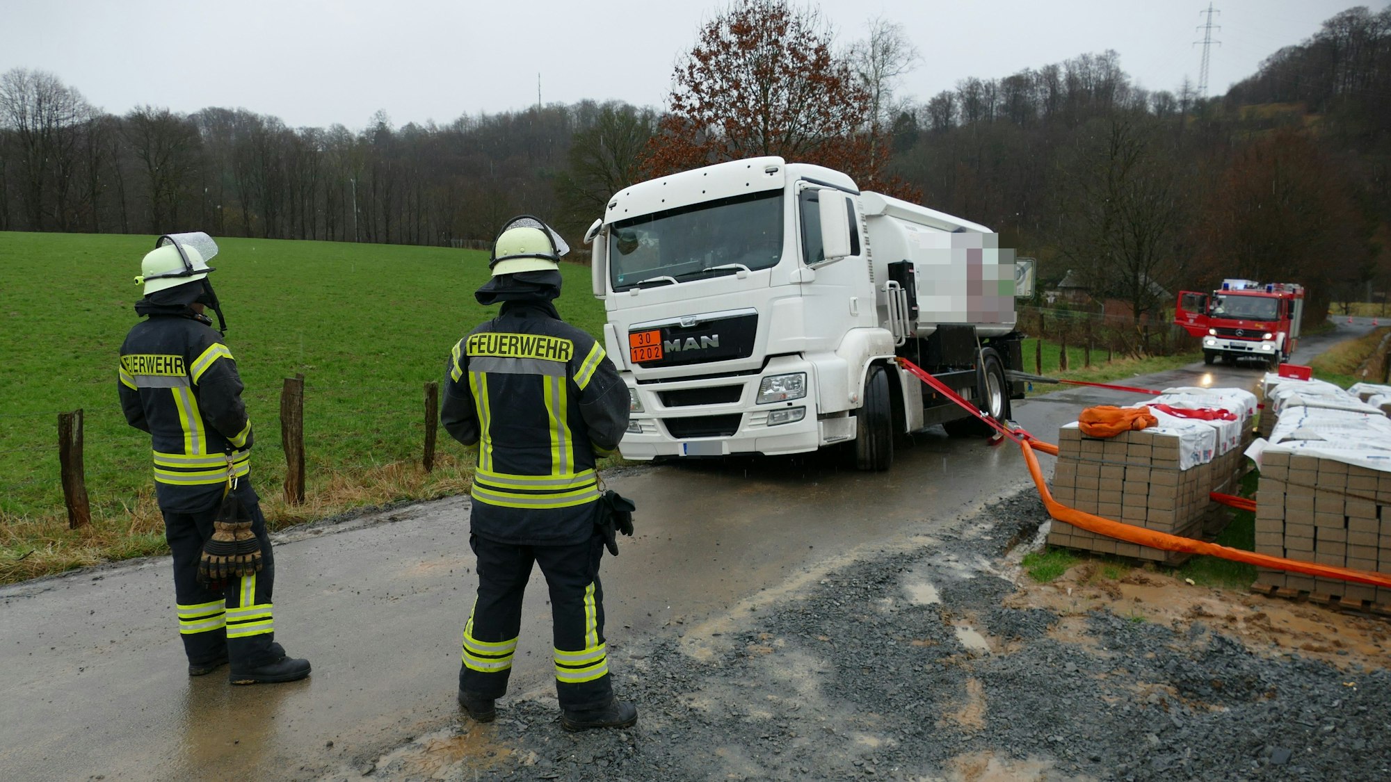 Mit Pflaster für eine nahe Baustelle hinderte die Feuerwehr den Tanklaster gegen das Abrutschen in den nahen Siefen.