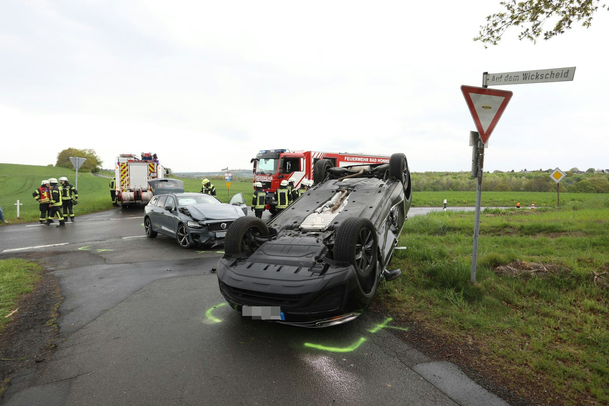 Nach einem Unfall liegt ein Auto auf dem Dach, ein zweites Fahrzeug hat eine beschädigte Frontpartie.