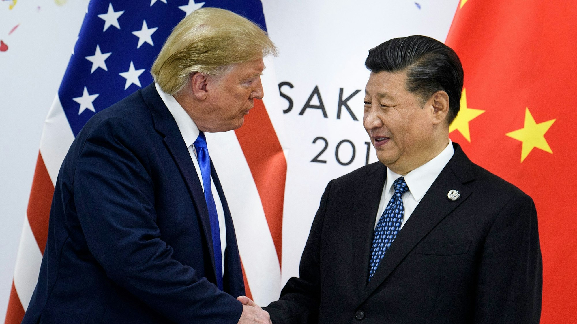 (FILES) This file photo taken on June 28, 2019 shows China's President Xi Jinping (R) shaking hands with US President Donald Trump before a bilateral meeting on the sidelines of the G20 Summit in Osaka. With his storm of tariffs on Chinese goods, US President Donald Trump on April 2025 has torched ties with Beijing and likely wrecked any hope of meeting his counterpart Xi Jinping in the near term, analysts say. (Photo by Brendan Smialowski / AFP) / To go with AFP story China-US-diplomacy-politics-trade-economy,ANALYSIS by Matthew Walsh