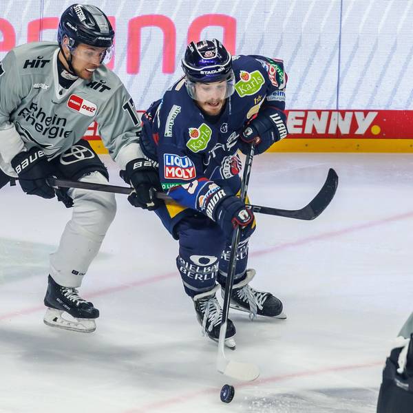 Jan Luca Sennhenn von den Kölner Haien kämpft gegen Berlins Topscorer Ty Ronning (r) um den Puck.