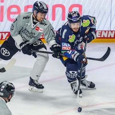 Jan Luca Sennhenn von den Kölner Haien kämpft gegen Berlins Topscorer Ty Ronning (r) um den Puck.
