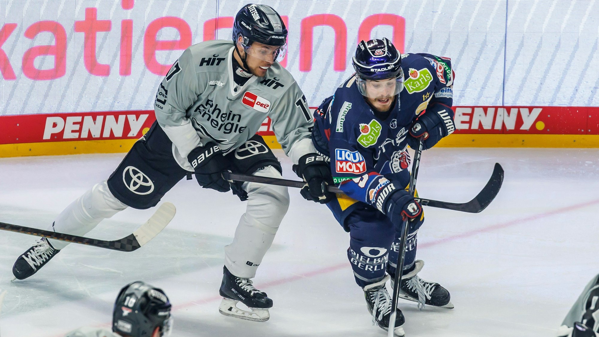 Jan Luca Sennhenn von den Kölner Haien kämpft gegen Berlins Topscorer Ty Ronning (r) um den Puck.