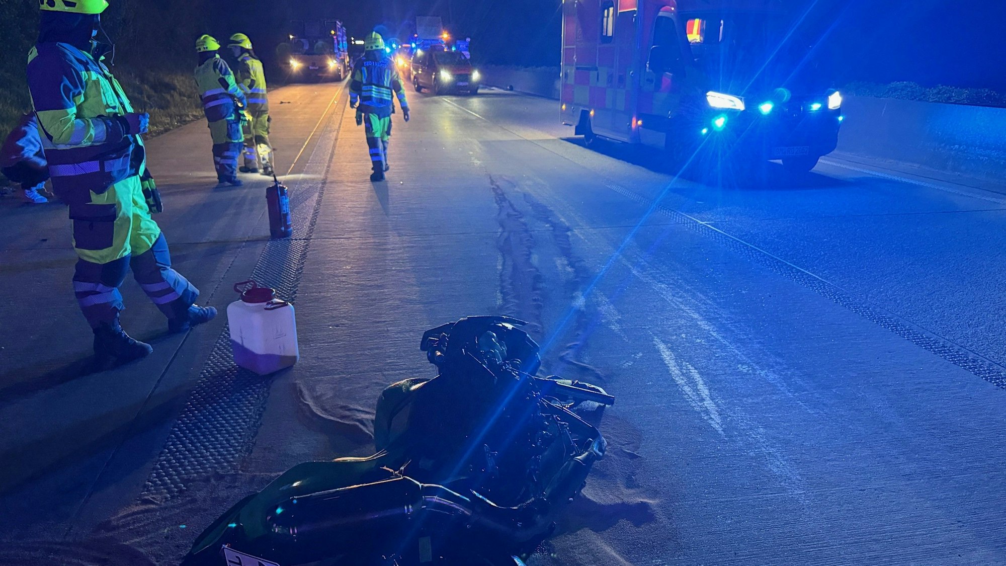 Das Bild zeigt Einsatzkräfte der Feuerwehr neben einem beschädigten Motorrad.