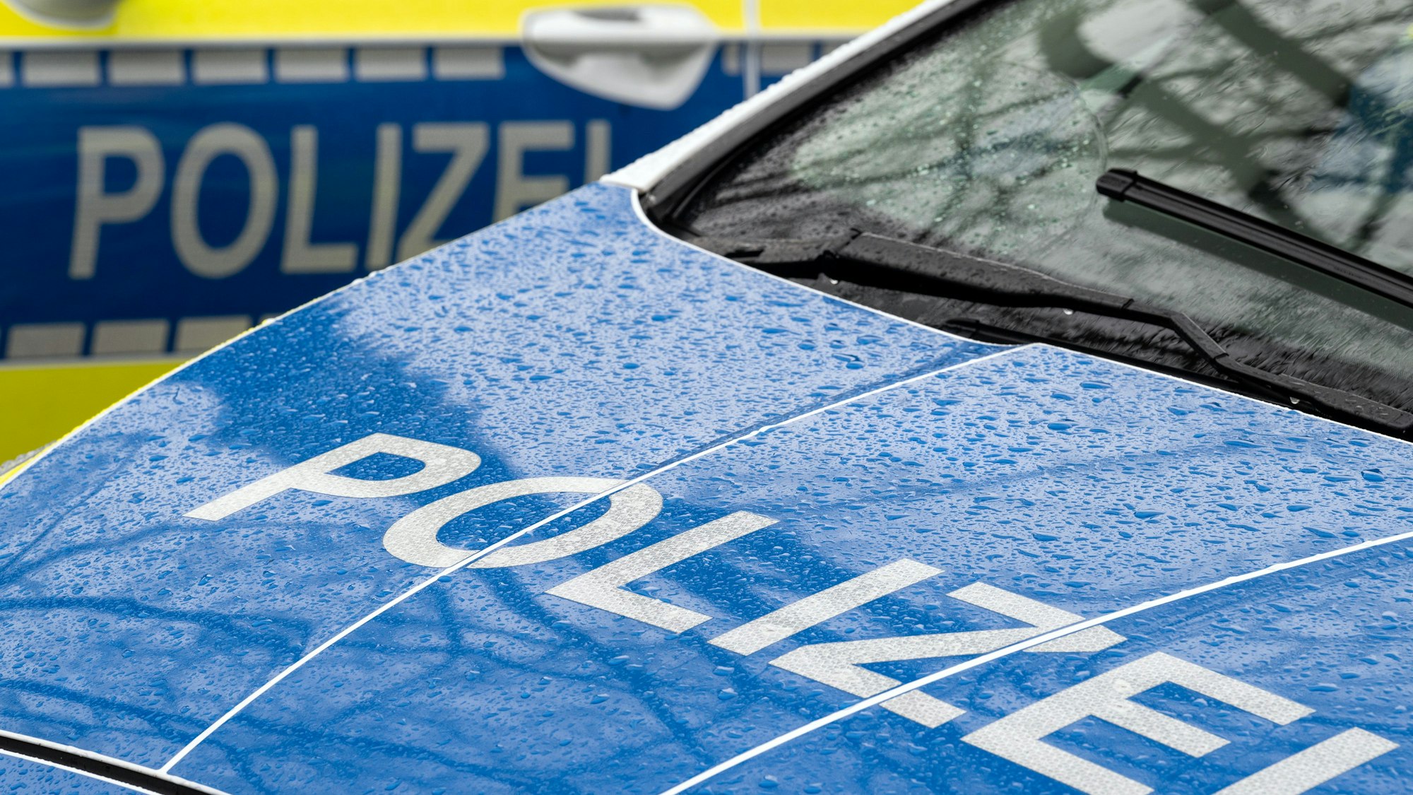 Zu sehen ist der Schriftzug „Polizei“ auf der Kühlerhaube eines Autos.