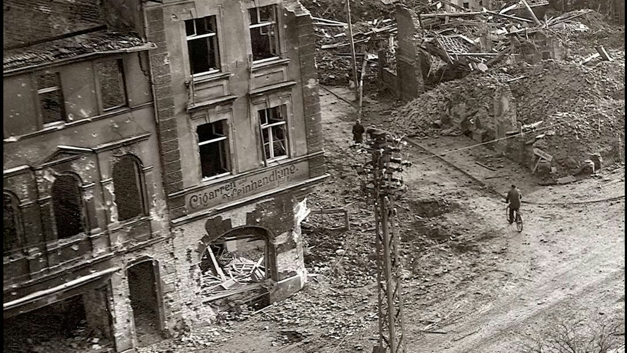 Zu sehen ist eine von Bomben zerstörte Innenstadt auf einem alten Schwarz-Weiß-Foto.