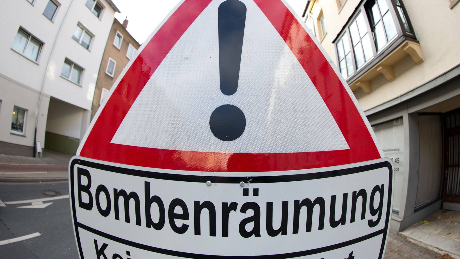 ARCHIV - 27.10.2013, Niedersachsen, Osnabrück: Auf einem Verkehrsschild wird auf eine Bombenräumung hingewiesen. Zum zweiten Mal in dieser Woche wird am Donnerstag in Köln ein Blindgänger entschärft. Teile der Unikliniken müssen geräumt werden. Rund 5800 Anwohner sind von der Evakuierung betroffen. Erst am vergangenen Dienstag mussten rund 10 000 Beschäftigte ihre Arbeitsplätze verlassen. (zu dpa: «Weltkriegsbombe gefunden: Stopp auf Bahnstrecken in Münster») Foto: Friso Gentsch/dpa +++ dpa-Bildfunk +++