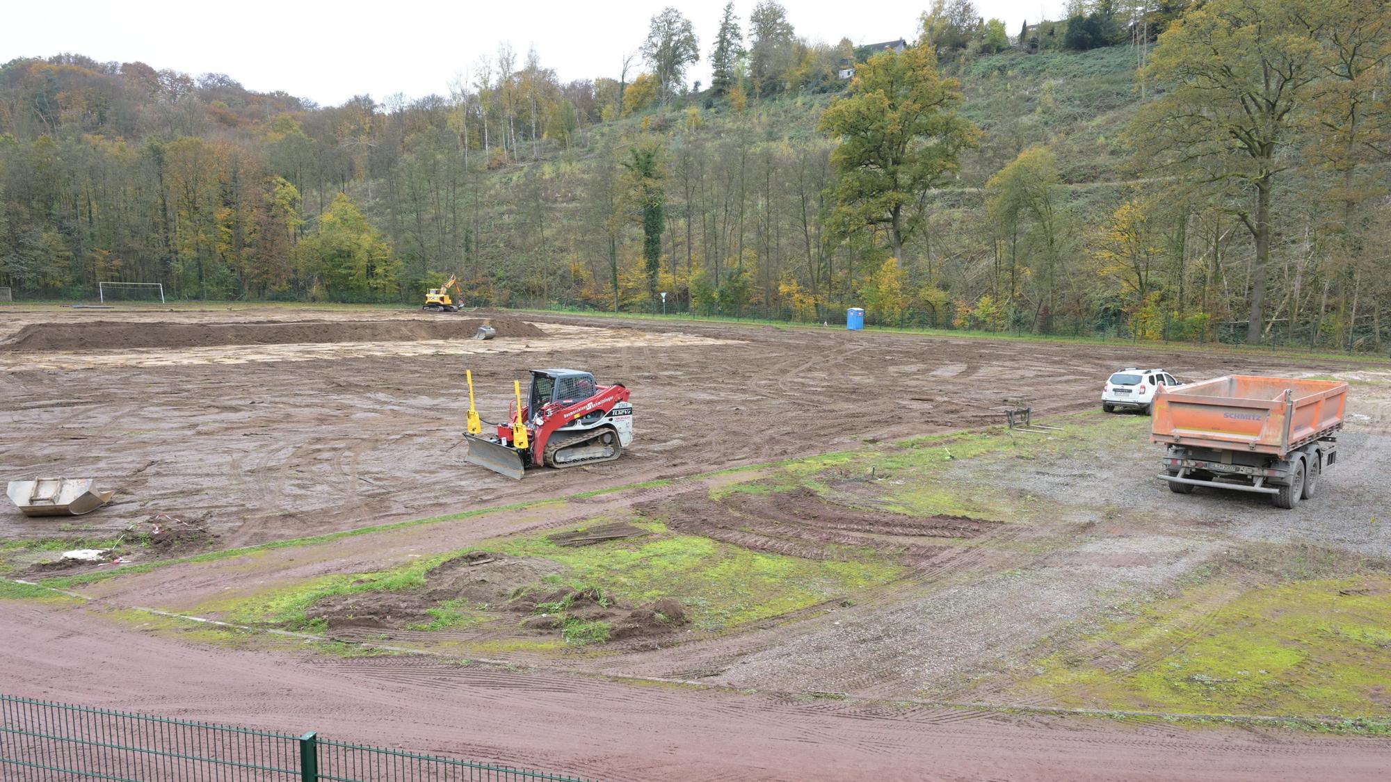 Ein Sportplatz wird umgegraben. Baufahrzeuge stehen auf der ehemaligen Rasenfläche.