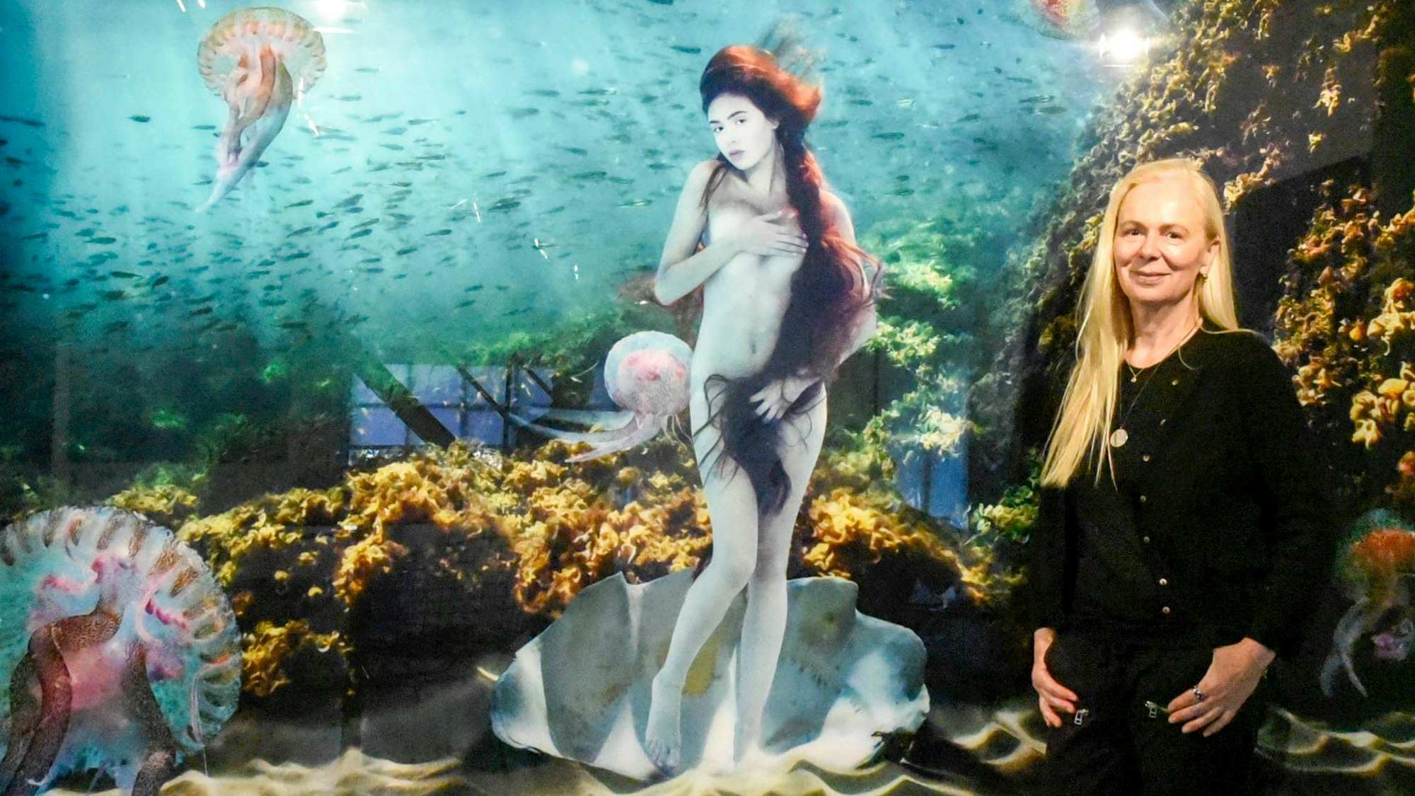 Eine Frau steht vor einem Bild, einer Unterwasser-Komposition von Botticellis Venus.