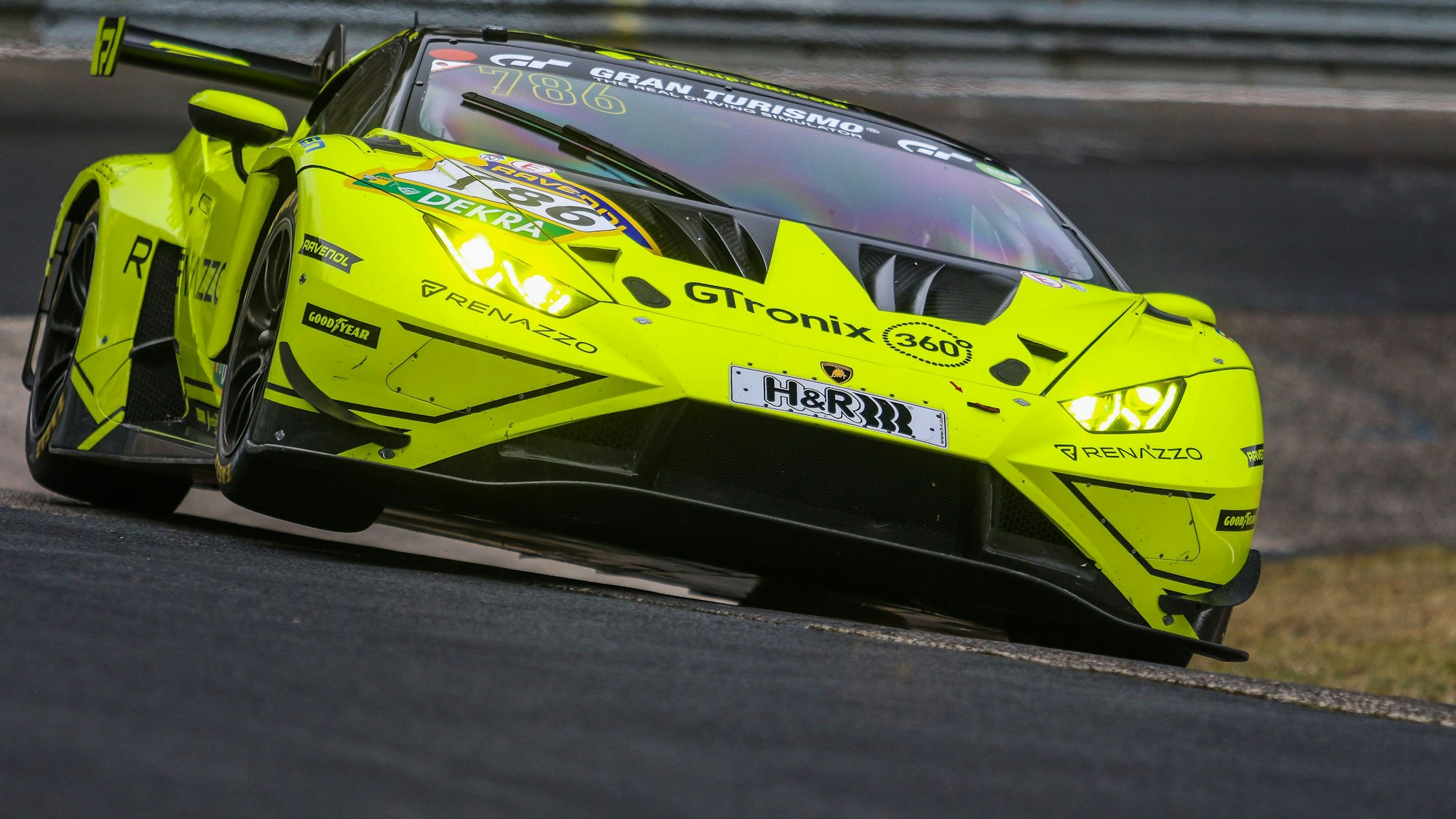 Ein gelbes Rennauto fährt aus einer Kurve heraus.