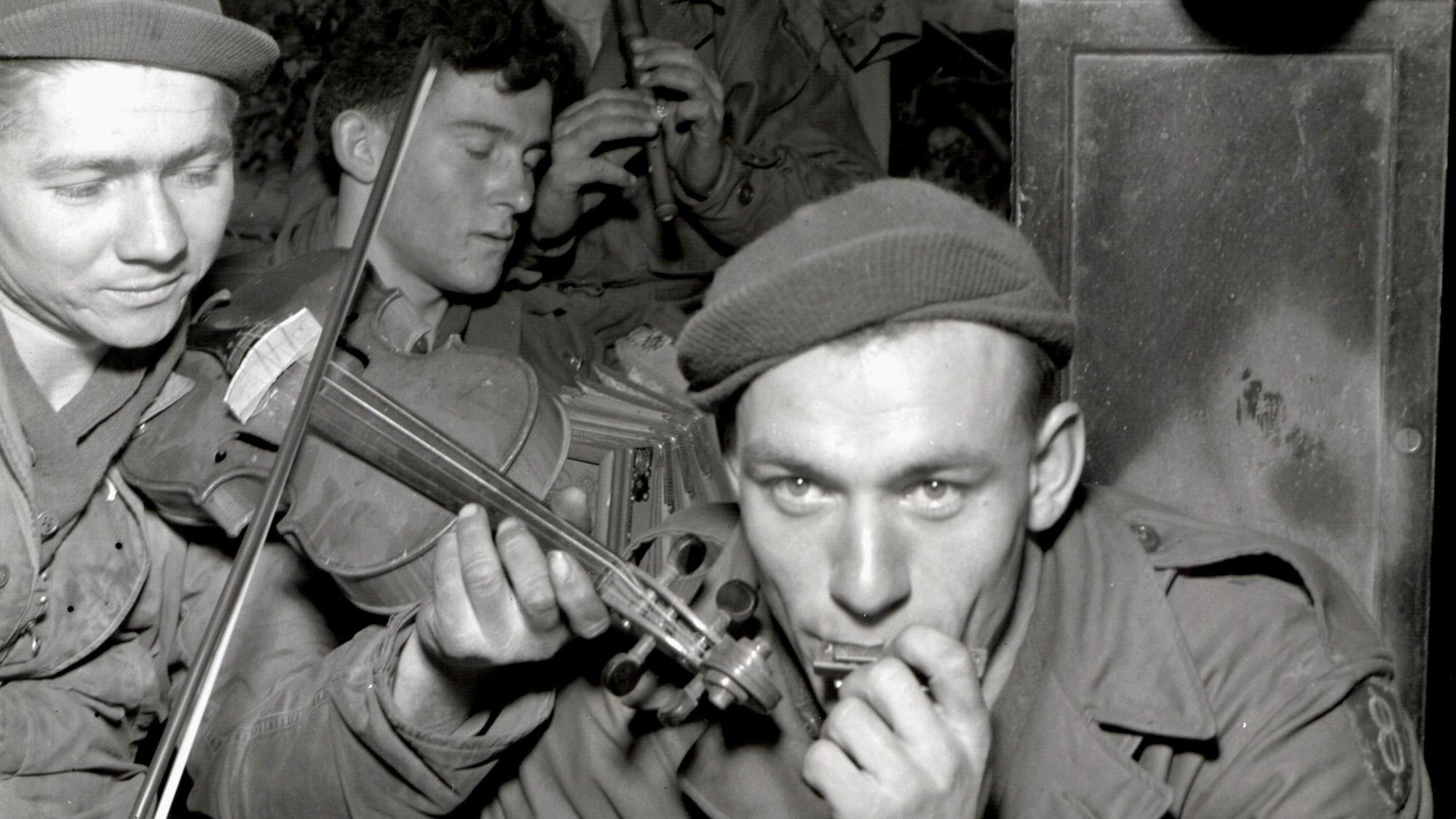 Zu sehen sind auf einem alten Schwarz-Weiß-Foto US-Soldaten, die musizieren.