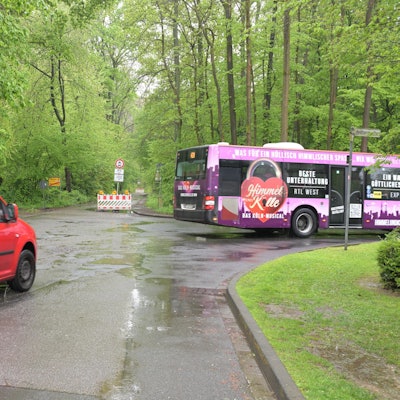 Ein Bus und ein Auto biegen vor einer Straßensperre nach rechts ab.