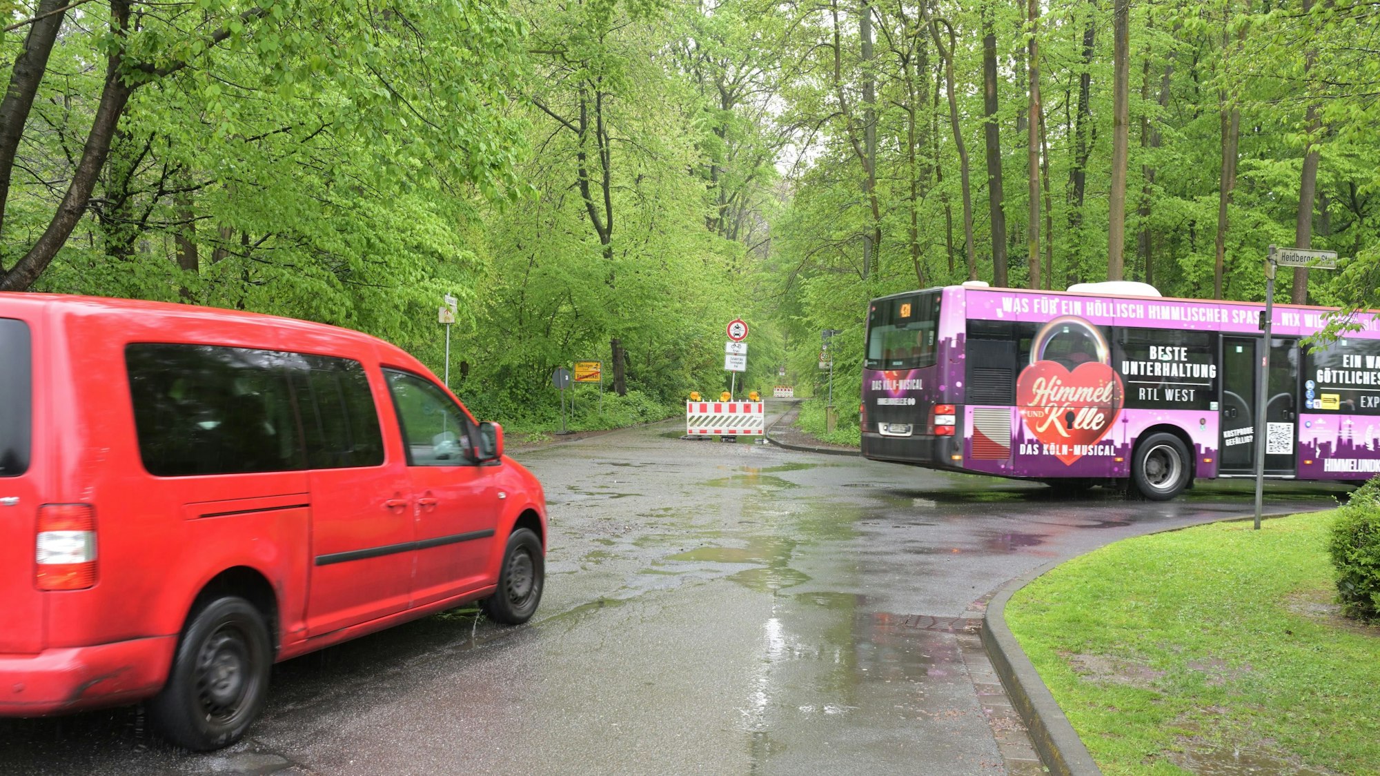 Ein Bus und ein Auto biegen vor einer Straßensperre nach rechts ab.