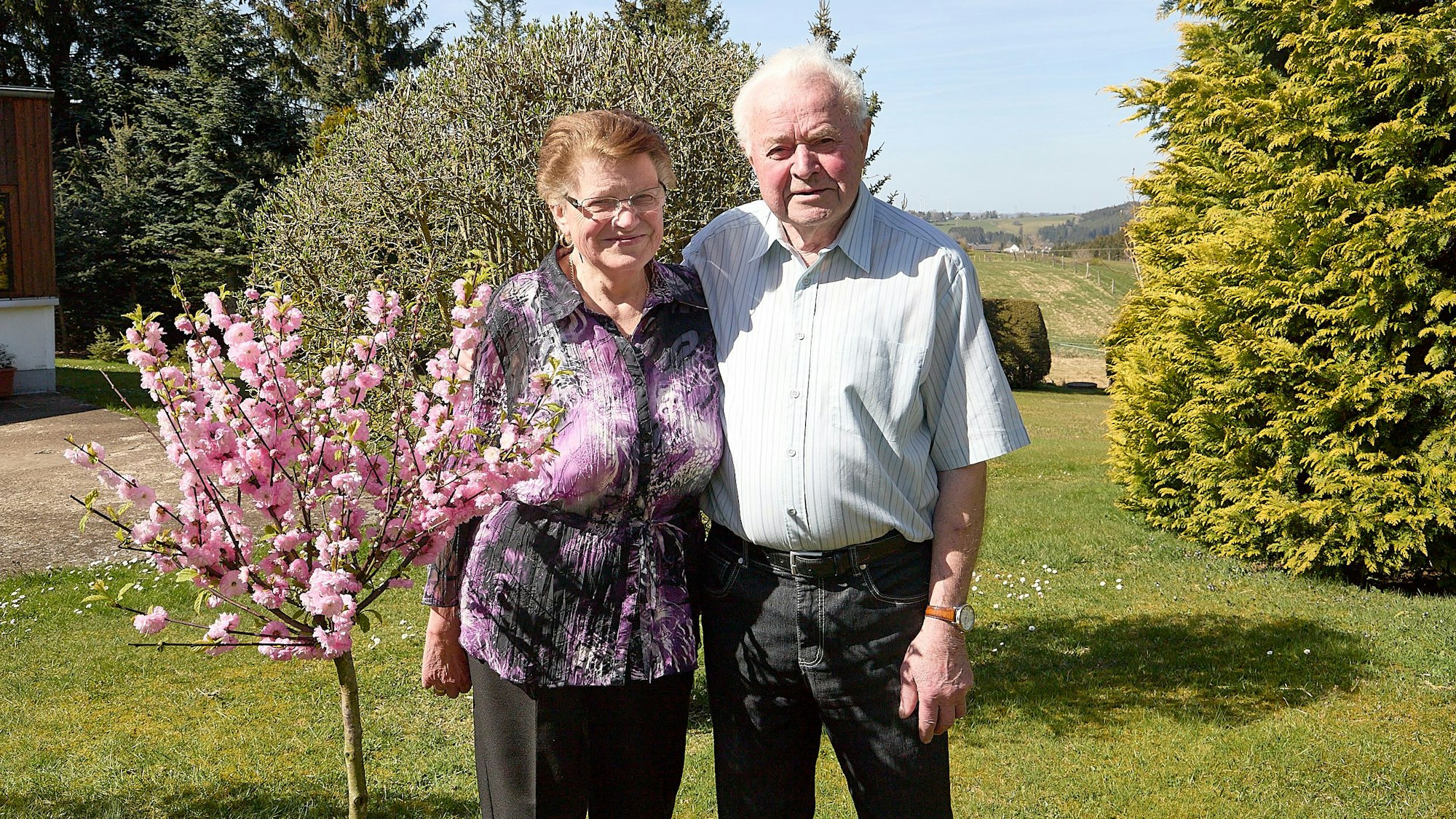 Ingeborg und Wilhelm Hermes stehen neben einem blühenden Bäumchen.