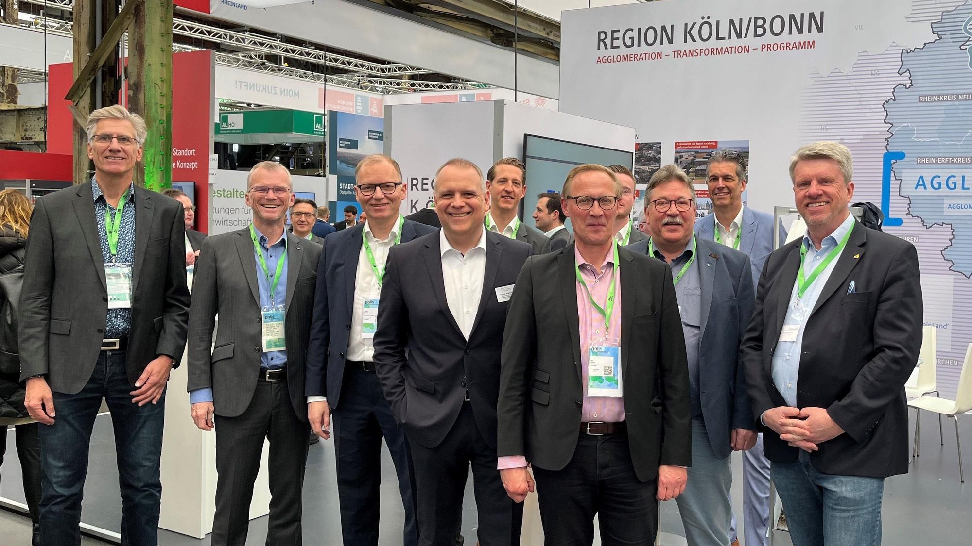 Menschen stehen vor einem Messestand.
