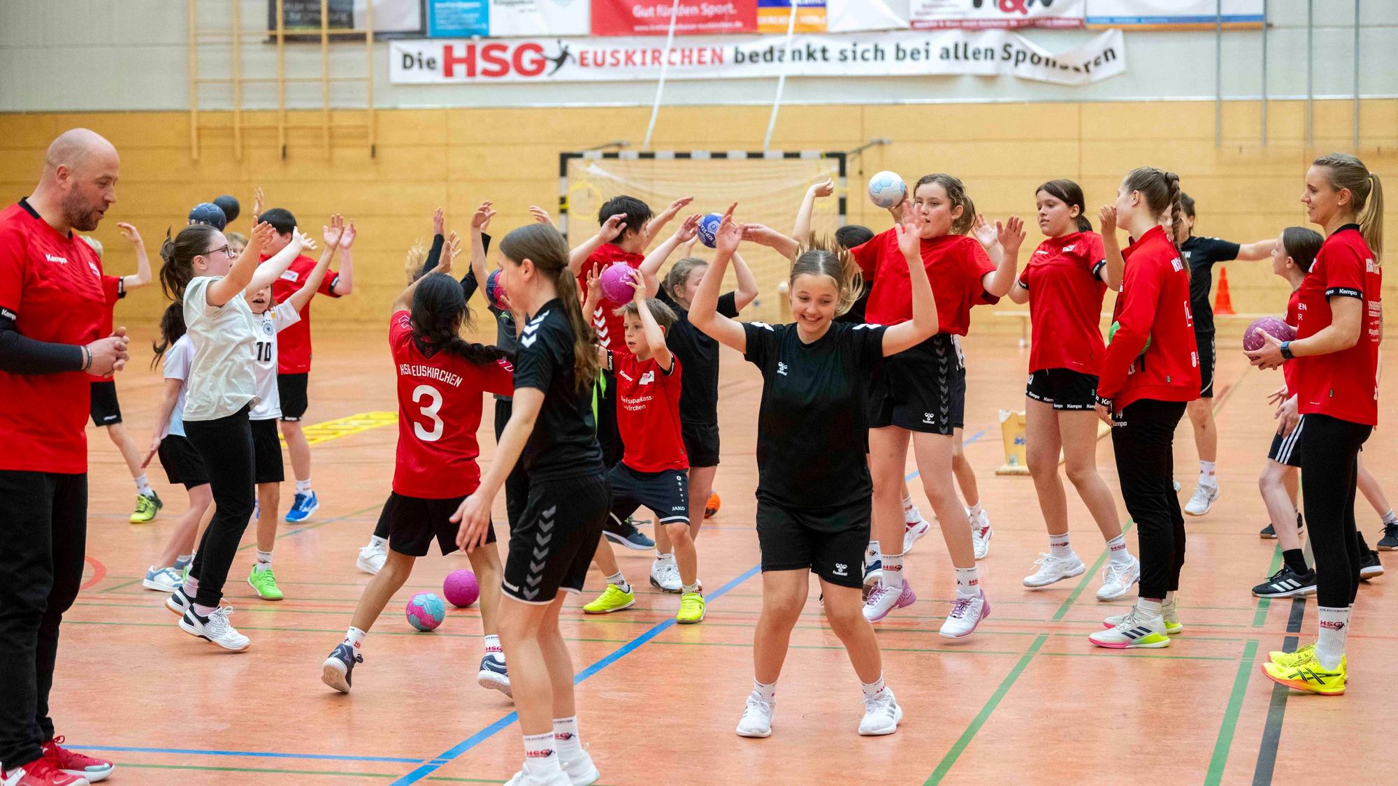 Nachwuchshandballer machen in einer Sporthalle Übungen.