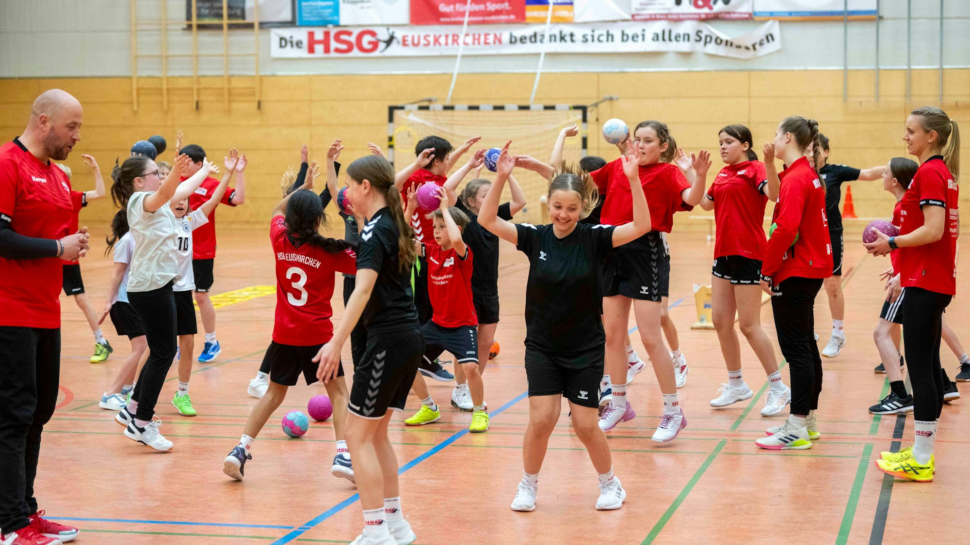 Nachwuchshandballer machen in einer Sporthalle Übungen.