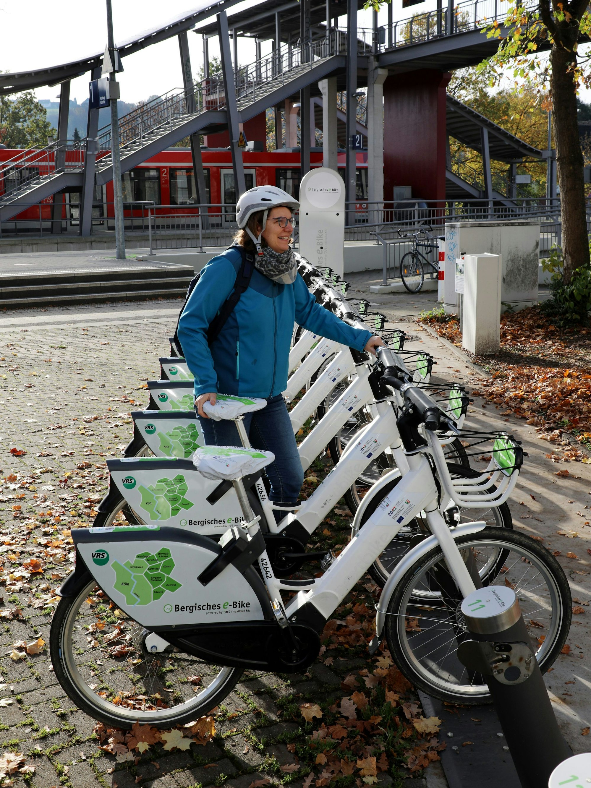 Eine Frau leiht ein Bergisches E-Bike an der Mobilstation am Overather Bahnhof aus.