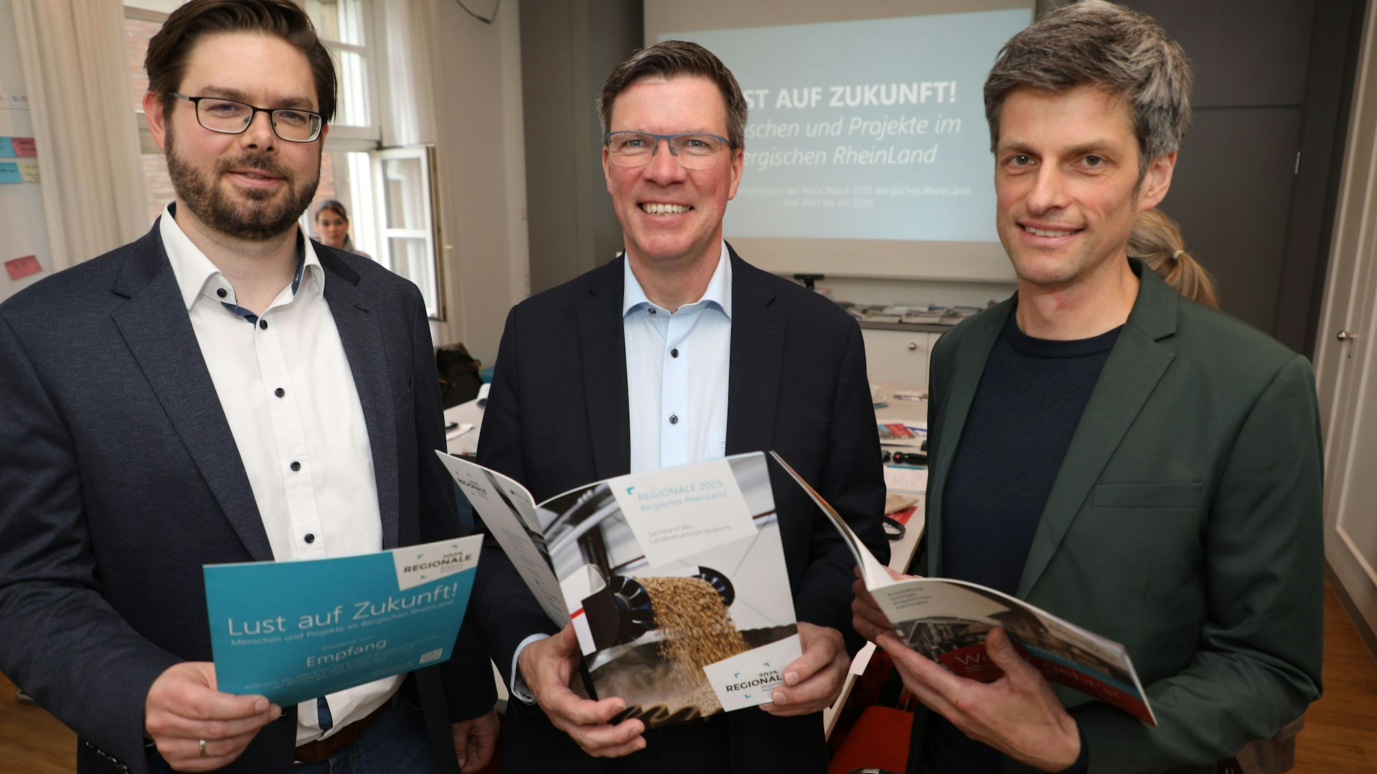 Regionale-Vize-Geschäftsführer Thomas Kemme, Landrat Stephan Santelmann und Dezernent Heiko Krause. schauen in Programmhefte der Regionale 2025.