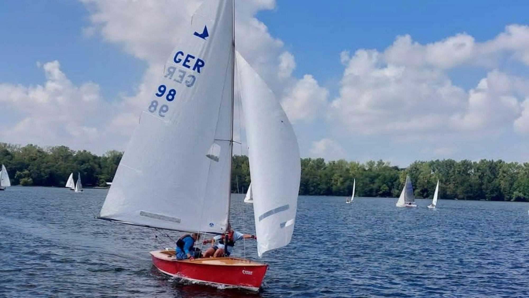 Zu sehen ist ein Segelboot auf einem See.