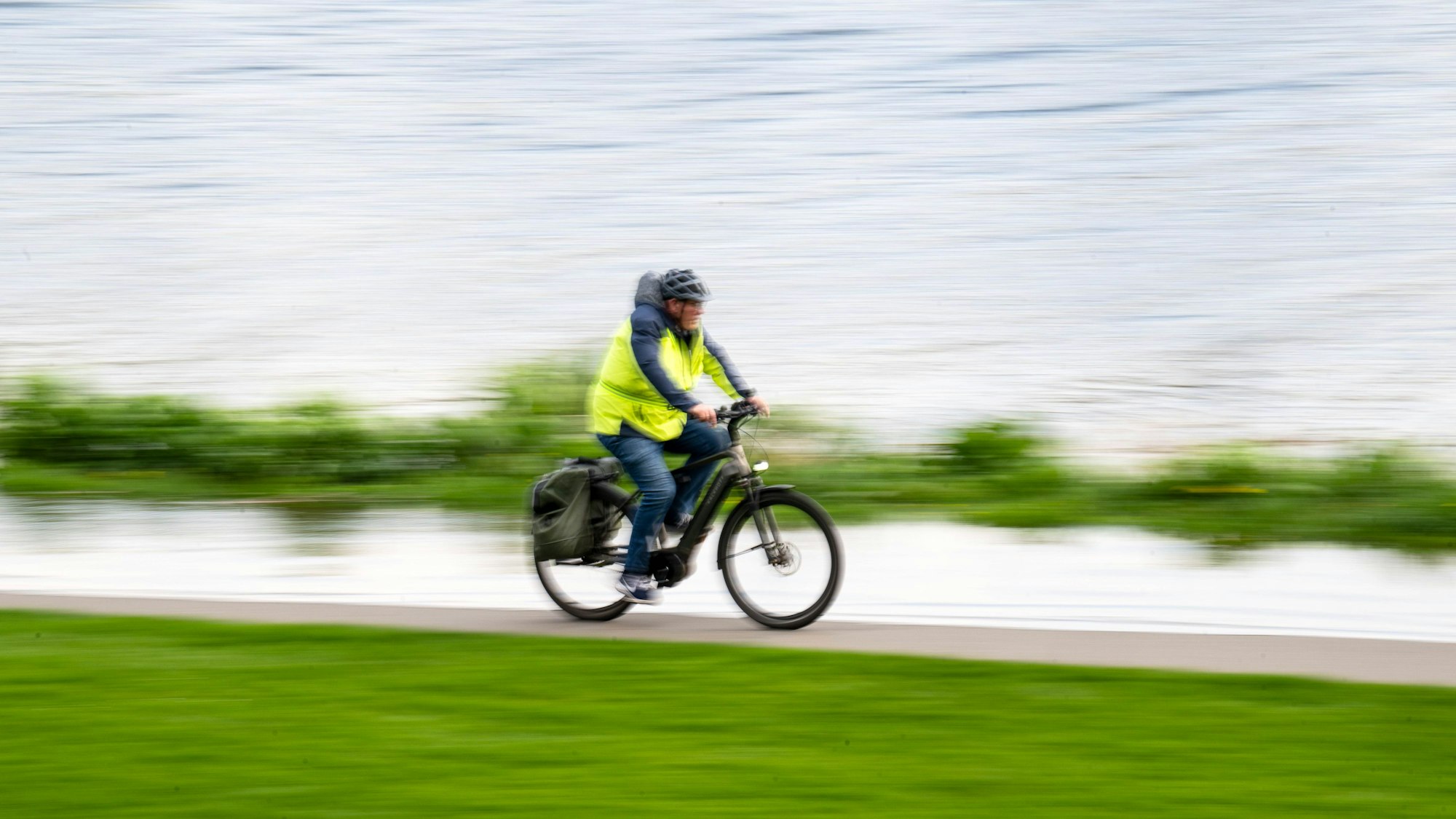 Ein Radfahrer fährt auf einem Weg entlang eines Flusses.