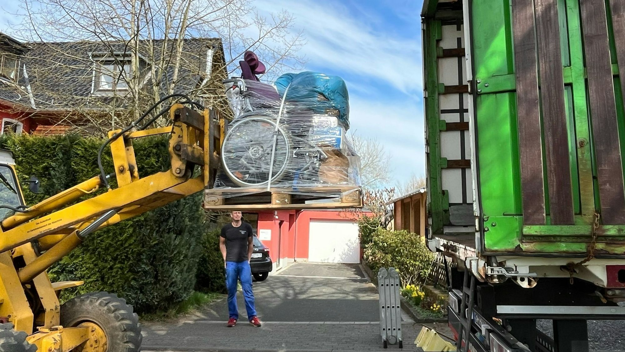 Ein Bagger verlädt Hilfsgüter in einen LKW.