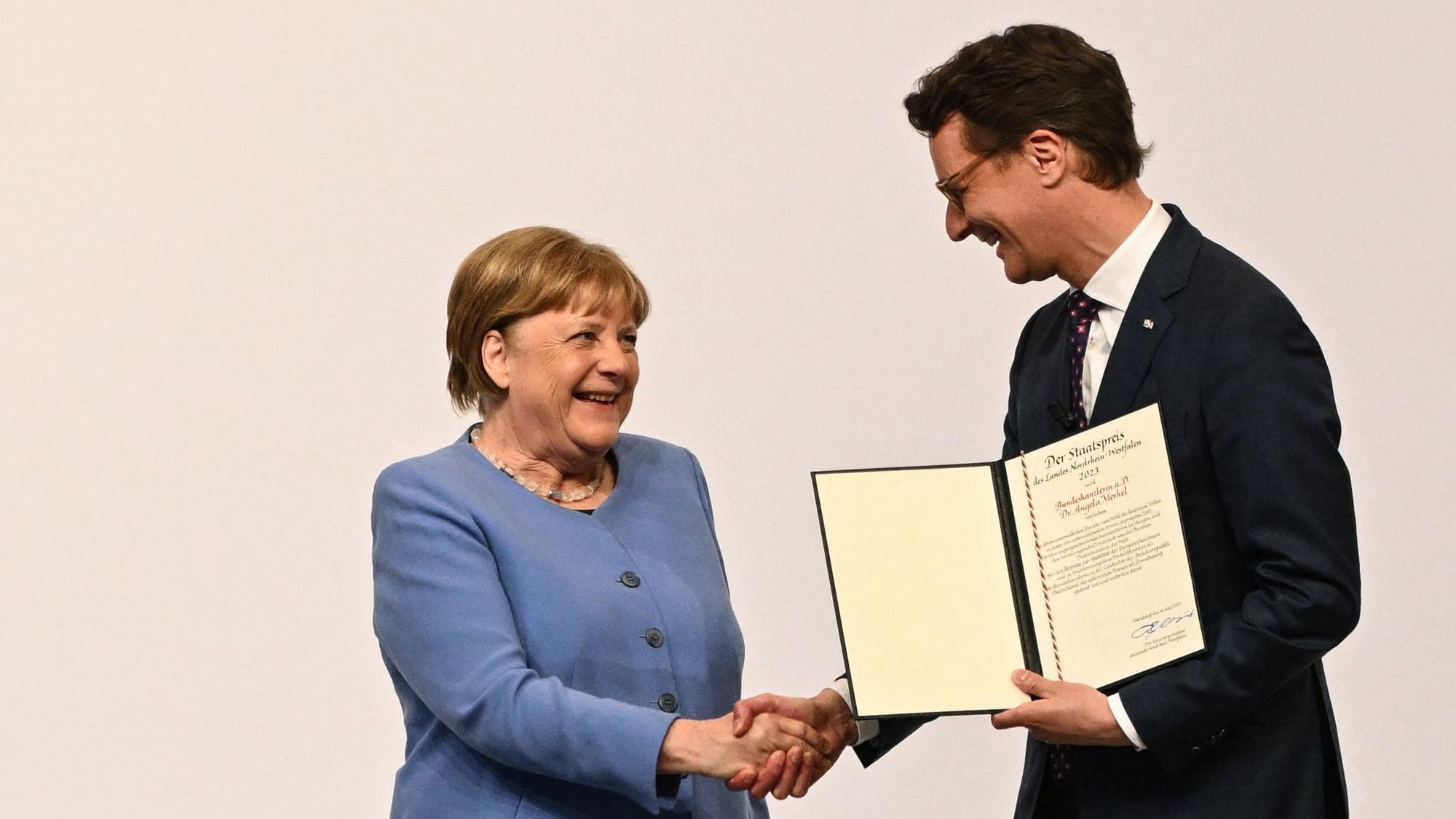 Ministerpräsident Wüst unterhält gute Verbindungen zu Ex-Kanzlerin Merkel. Hier überreicht er ihr den Staatspreis des Landes NRW. (Archiv)