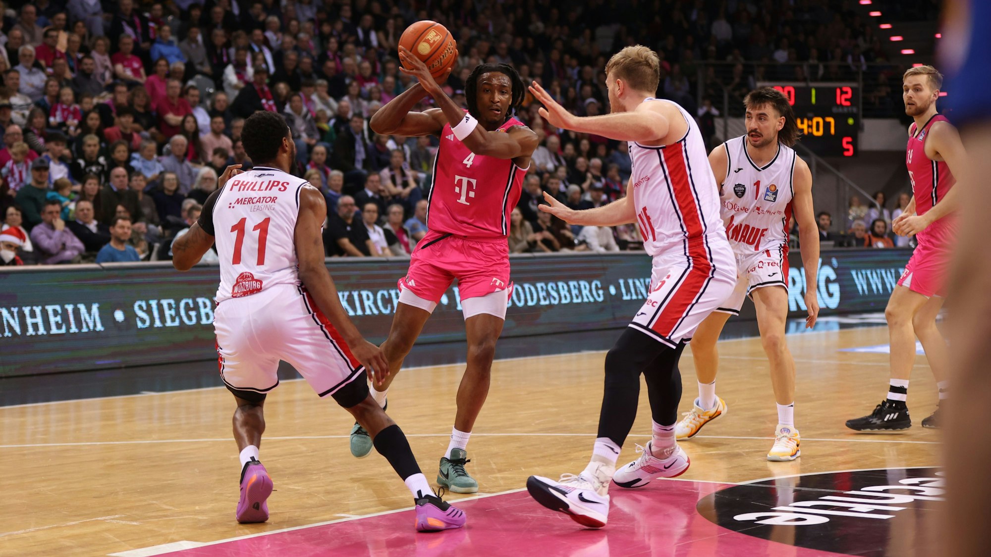 Bonns Phlandrous Fleming Jr. (Mitte) zieht gegen die Würzburger Nelson Philips (l.) und Maximilian Ugrai zum Korb.