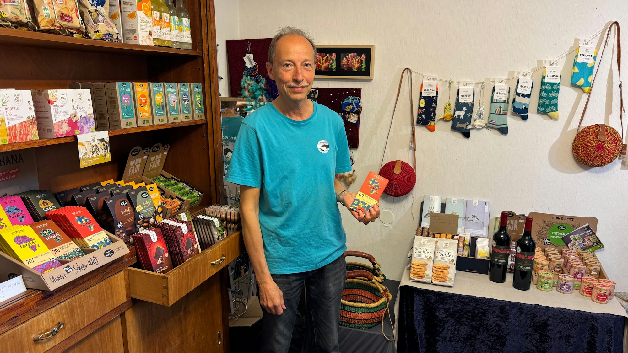 Das Foto zeigt Wolfgang Wettig, der Produkte des Fairen Marktes zeigt.