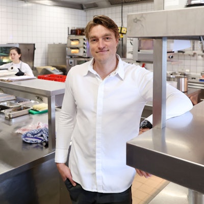 Ein Mann - er ist Küchenchef - steht in der Küche eines Restaurants.