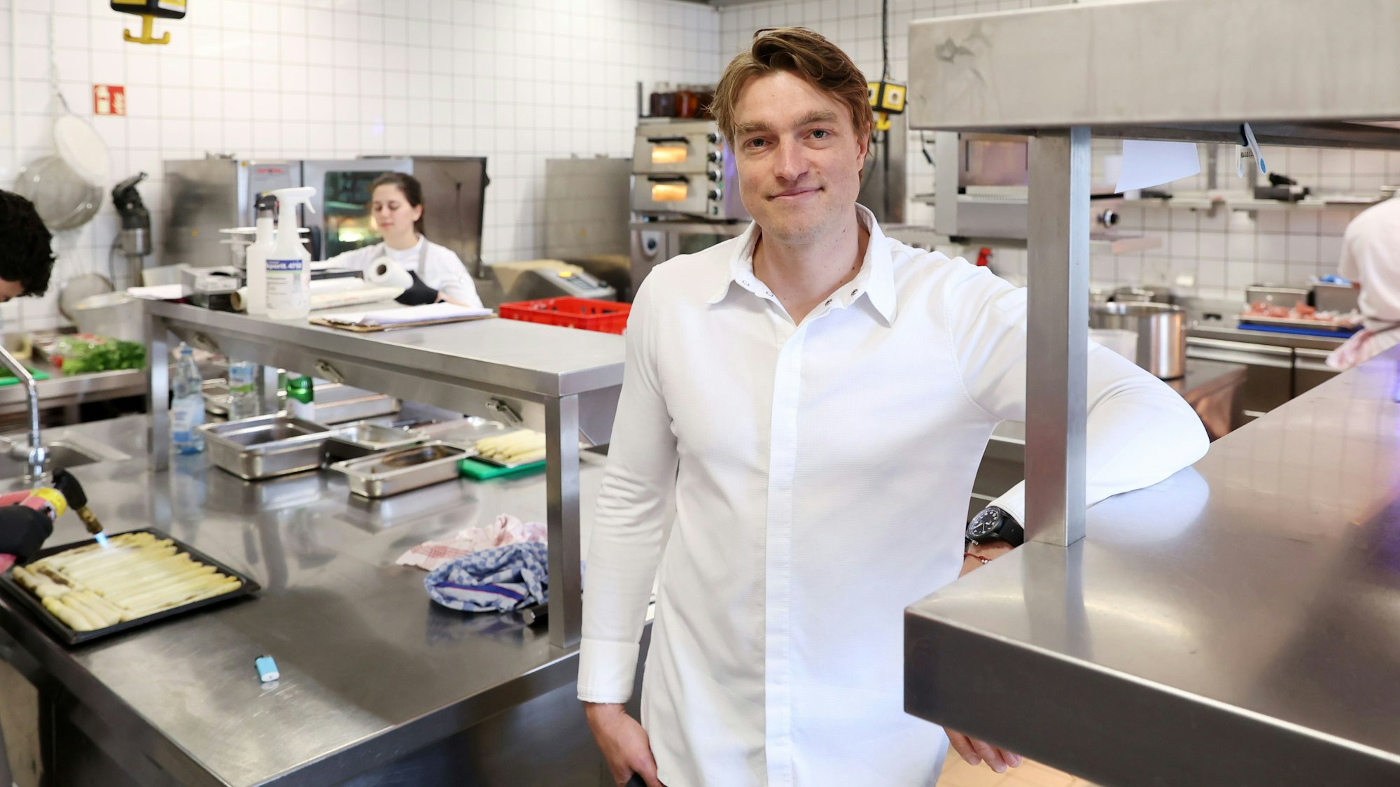 Ein Mann - er ist Küchenchef - steht in der Küche eines Restaurants.