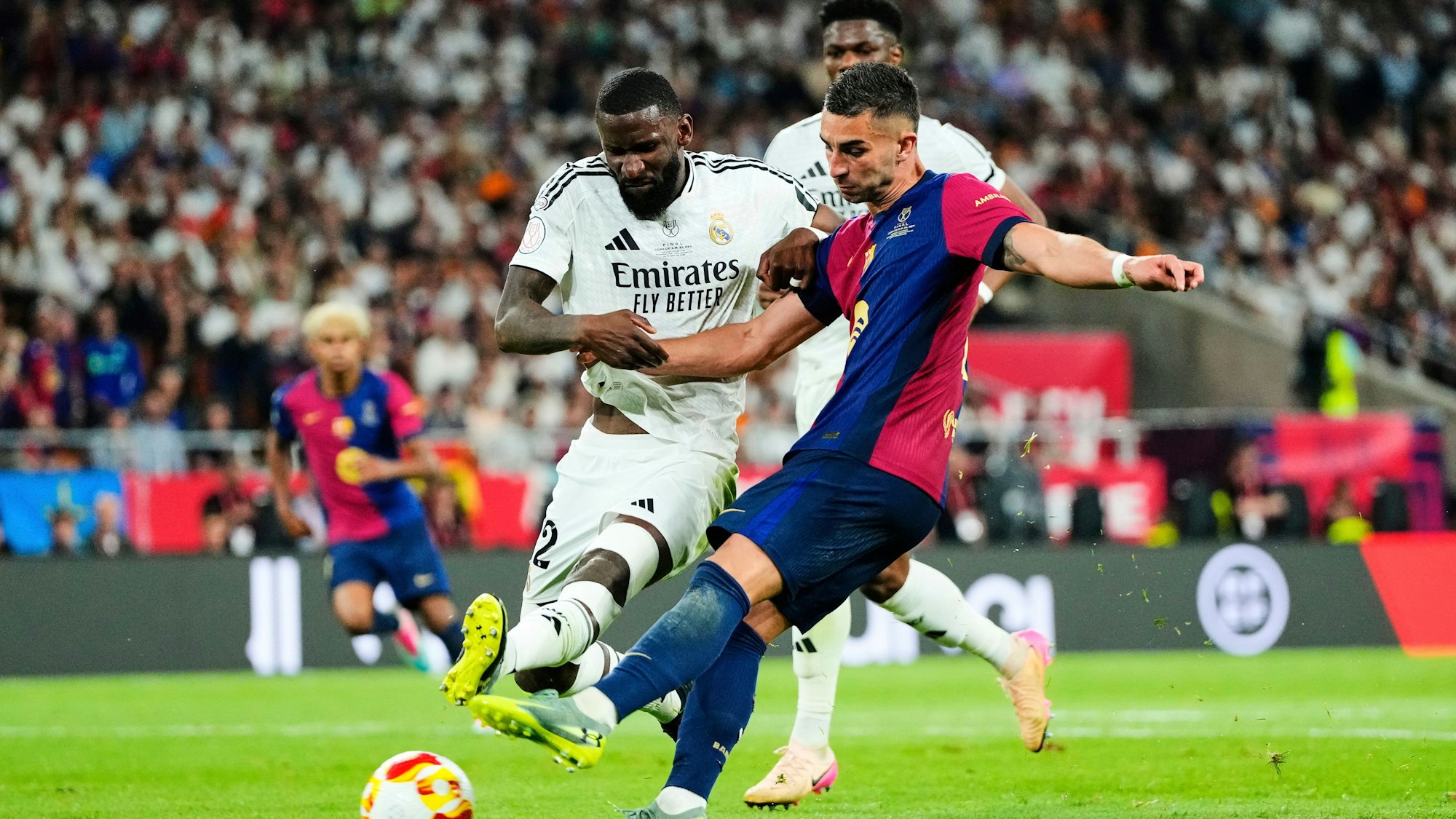 27.04.2025, Spanien, Sevilla: Fußball: Pokal Spanien, FC Barcelona - Real Madrid, Finale, Stadion Estadio de La Cartuja. Real Madrids Antonio Rüdiger (l) kämpft mit Barcelonas Ferran Torres um den Ball. Foto: Jose Breton/AP/dpa +++ dpa-Bildfunk +++