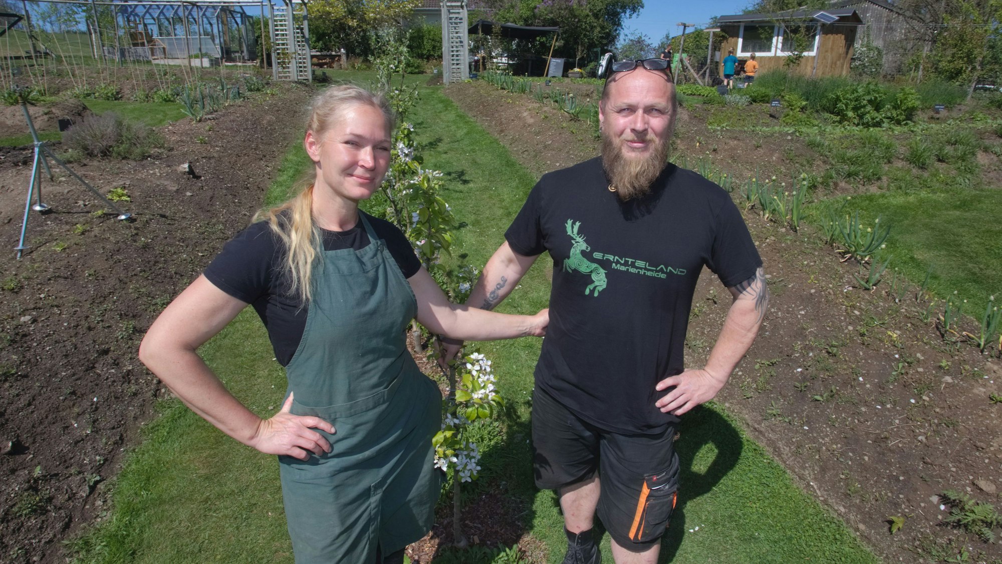 Ein Ehepaar steht in ihrem Garten – einem ökologischen Anbauprojekt.
