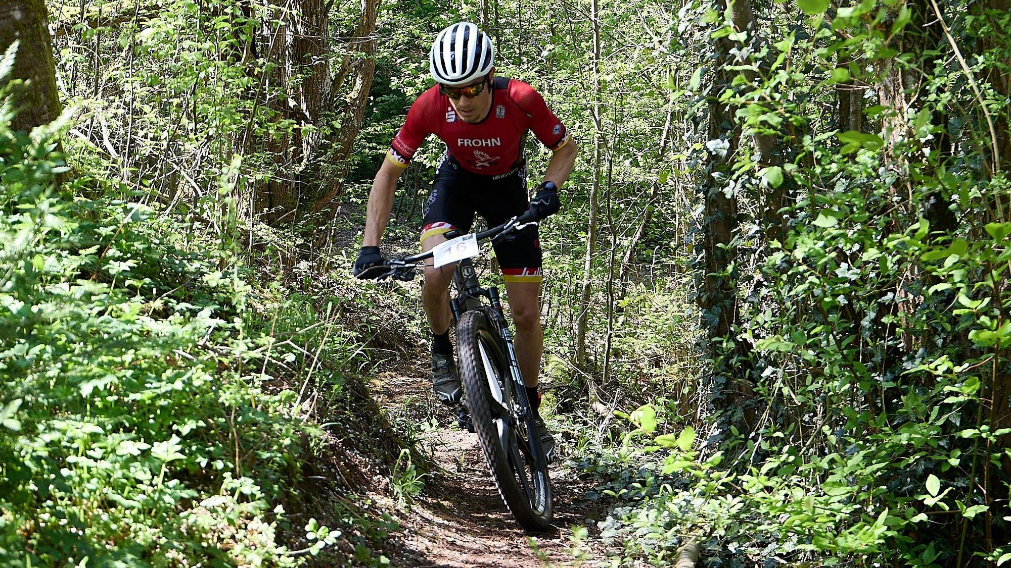Mathias Frohn fährt mit seinem Mountainbike durchs Unterholz.