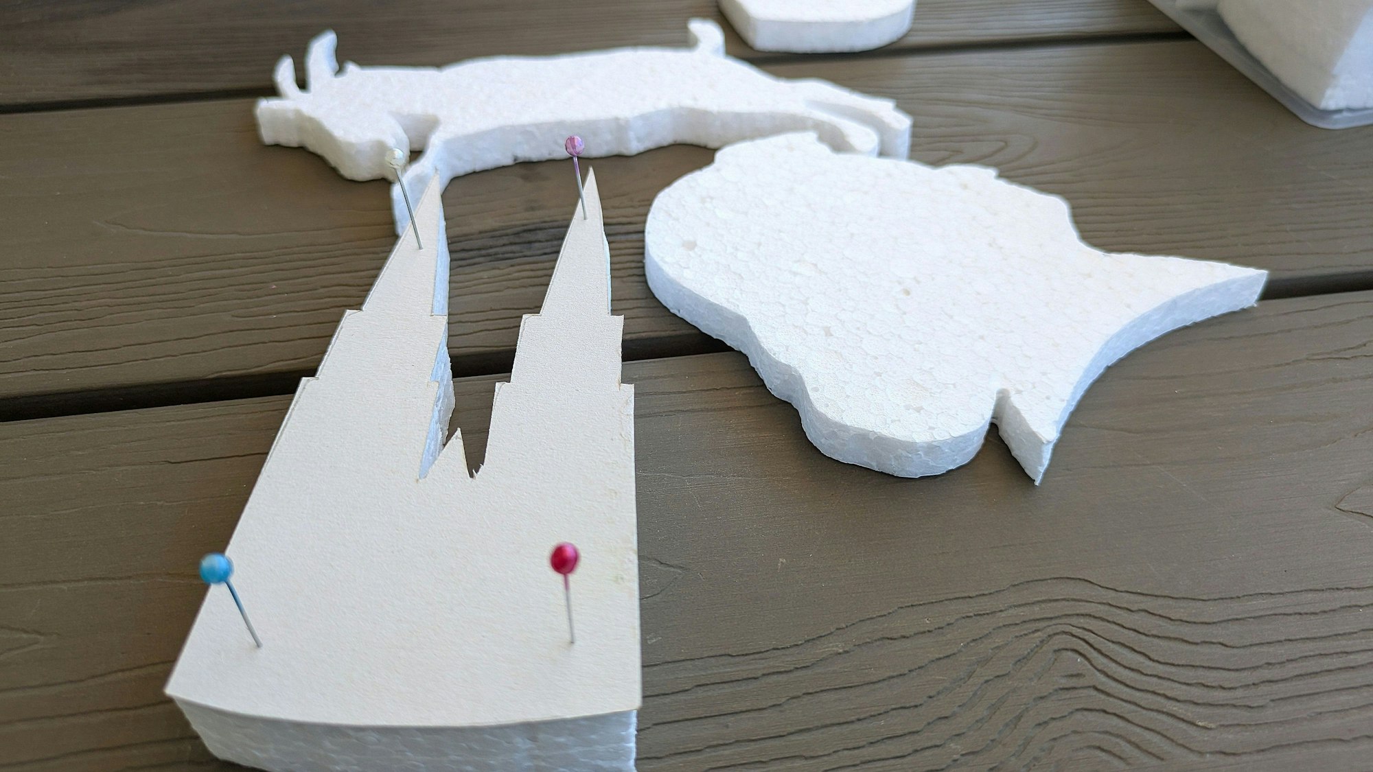 Schablonen aus Styropor liegen auf einem Tisch.