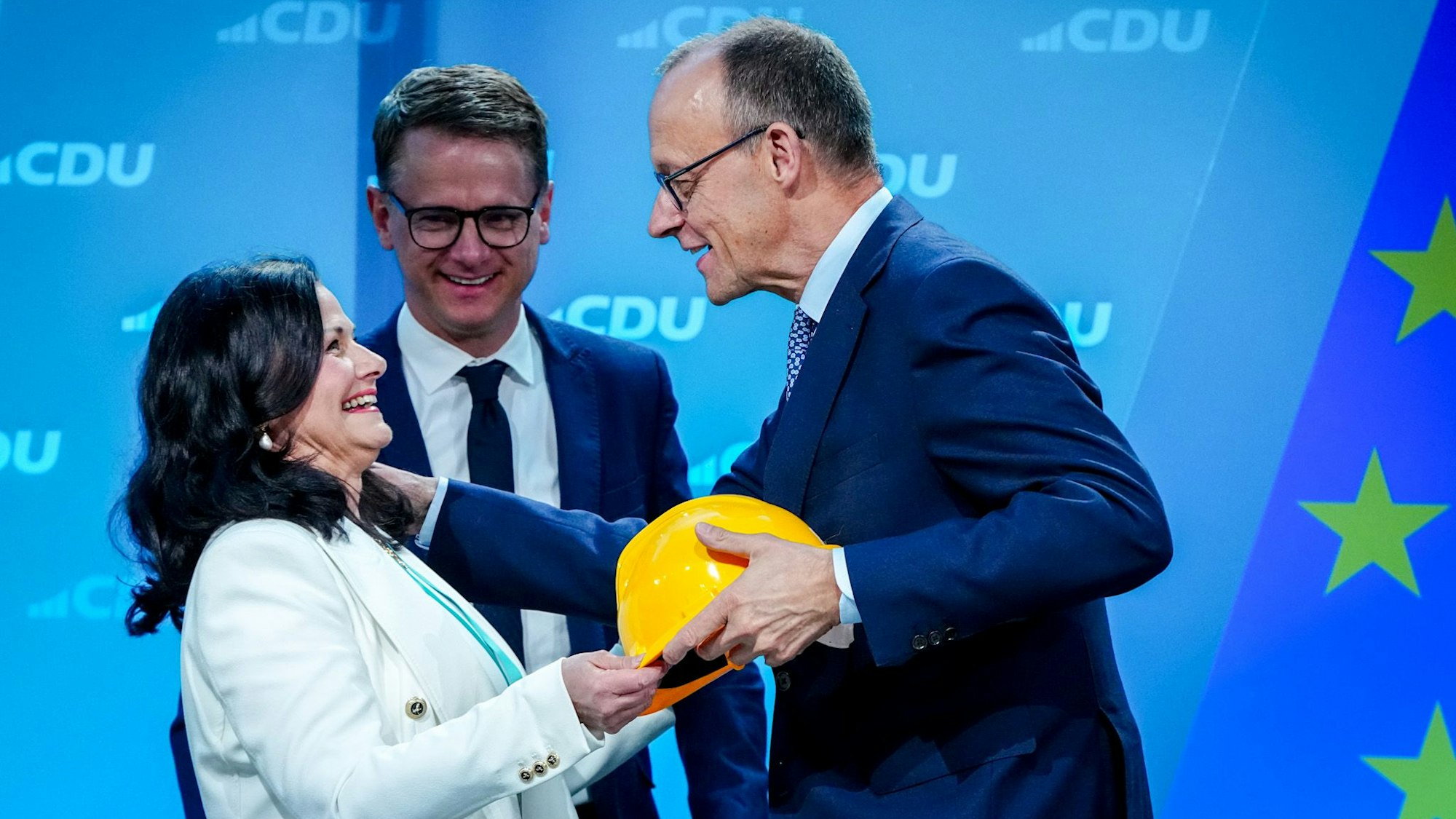 28.04.2025, Berlin: Gitta Connemann (CDU) überreicht einen Helm an Friedrich Merz (r), Unions-Kanzlerkandidat und CDU-Bundesvorsitzender, beim Bundesausschuss der CDU neben Carsten Linnemann, CDU-Generalsekretär. Bei dem kleinen Parteitag der CDU soll die Zustimmung zu einem Koalitionsvertrag der Union mit der SPD zur Bildung einer Bundesregierung erfolgen und die künftigen Minister vorgestellt werde. Foto: Kay Nietfeld/dpa +++ dpa-Bildfunk +++