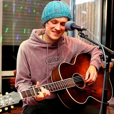 Der Singer-Songwriter Max Goedecke aus Mechernich spielt auf seiner Gitarre. Er stellte im „Em Domi“ seine erste CD vor.