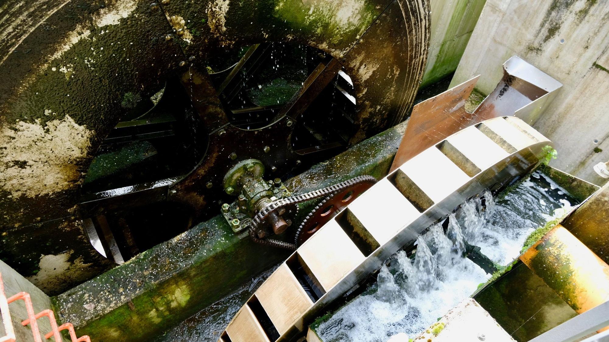 Ein größeres Wasserrad treibt ein kleineres Schöpfrad an.