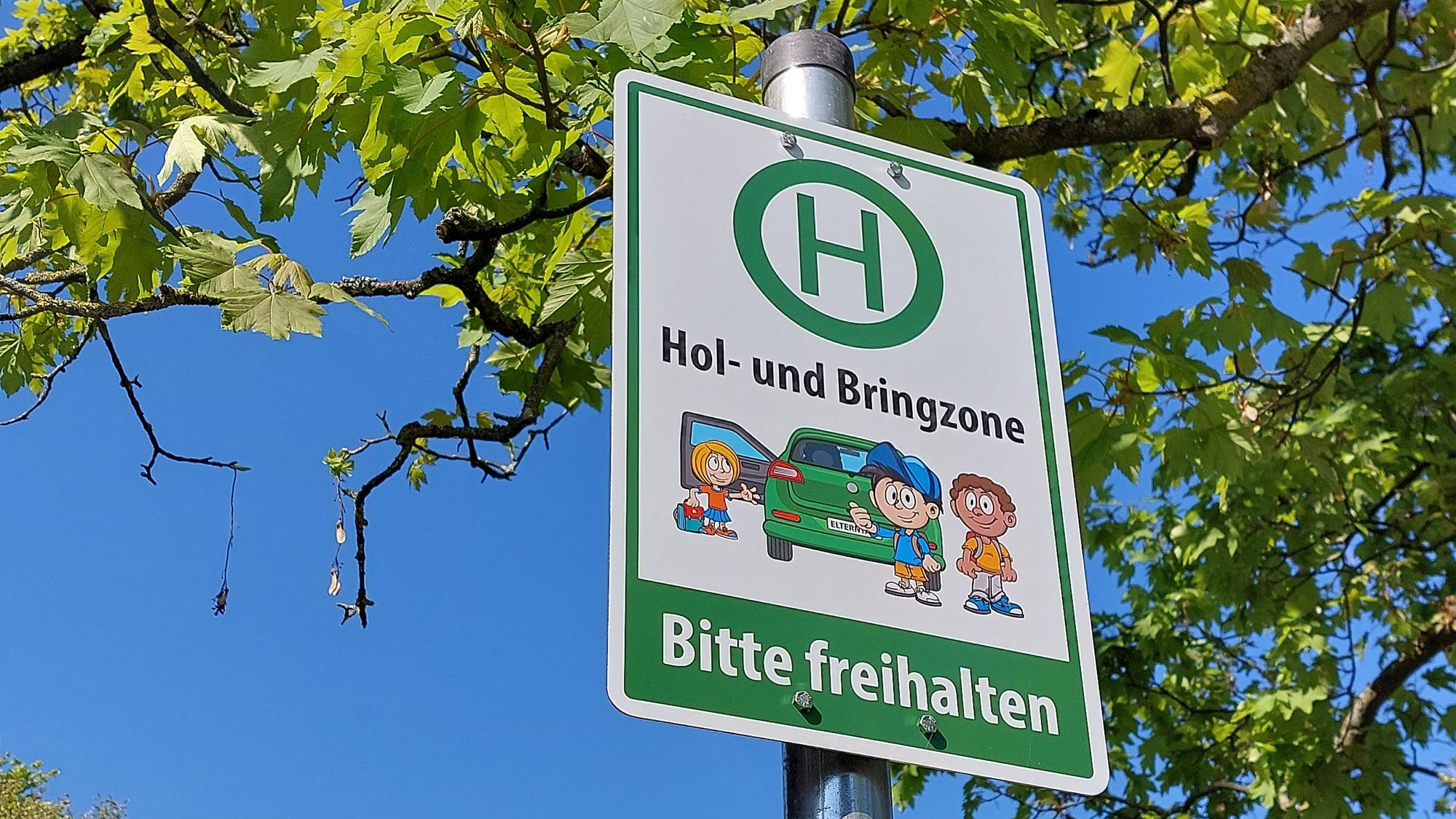 Ein Schild mit der Aufschrift "Hol- und Bringzone - Bitte freihalten"