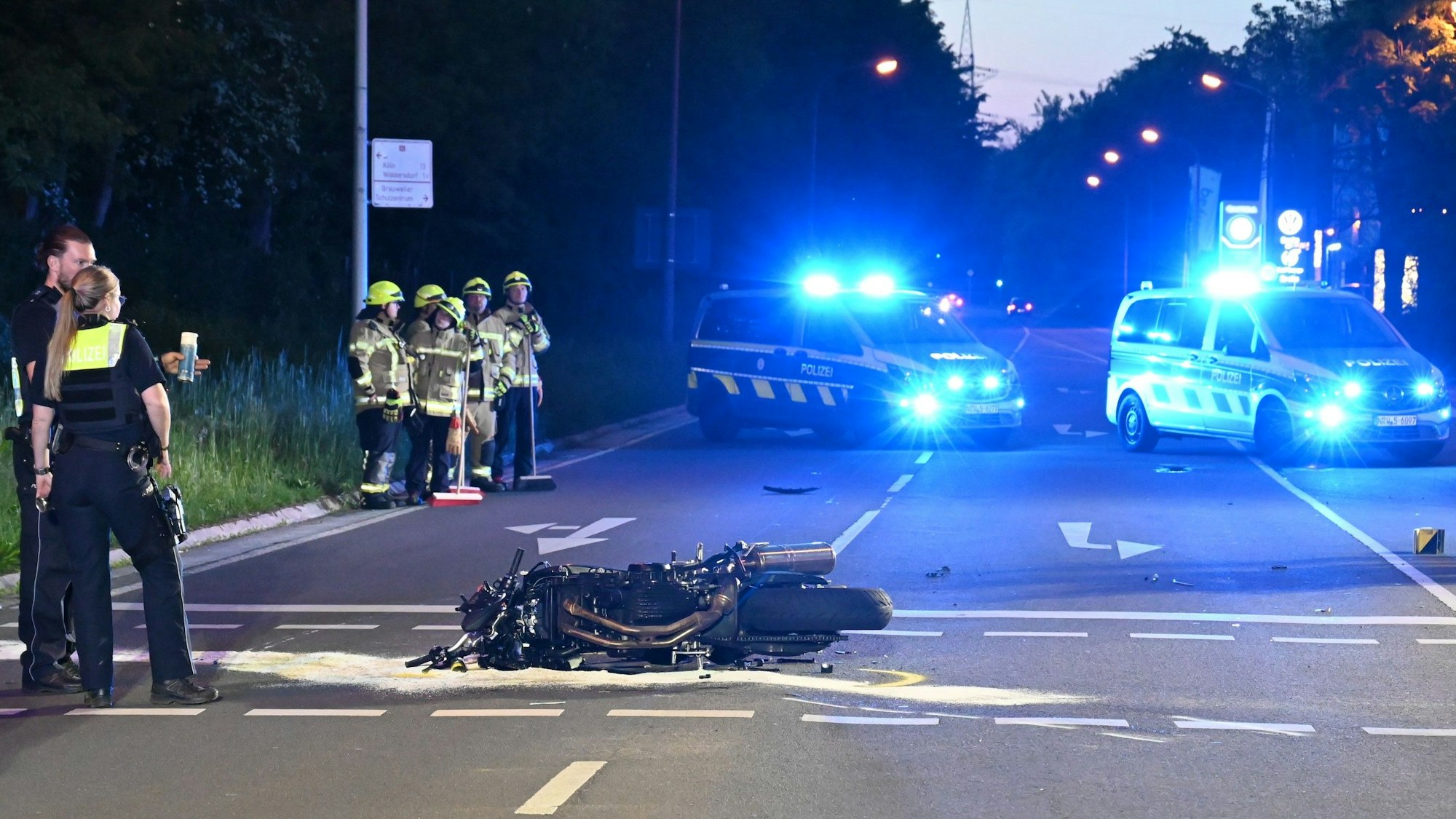 Das Bild zeigt mehrere Polizeikräfte an der Unfallstelle neben einem Motorrad.