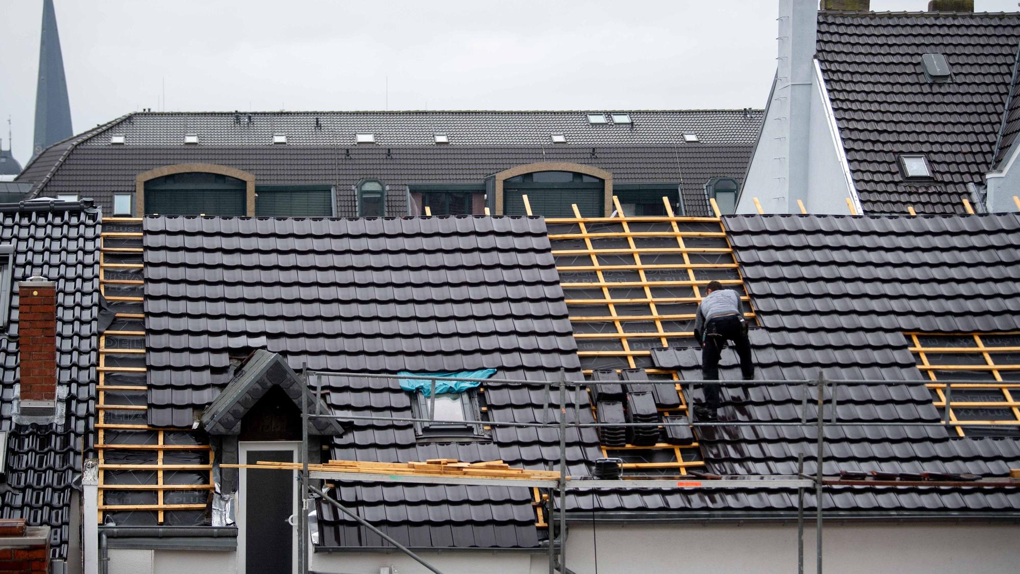 Ein Dachdecker deckt im Regen ein Dach in der Euskirchener Innenstadt.