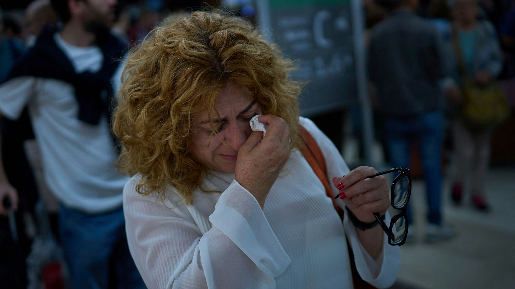 Paquita Gonzalez weint, während sie auf Informationen über die Zugabfahrten wartet