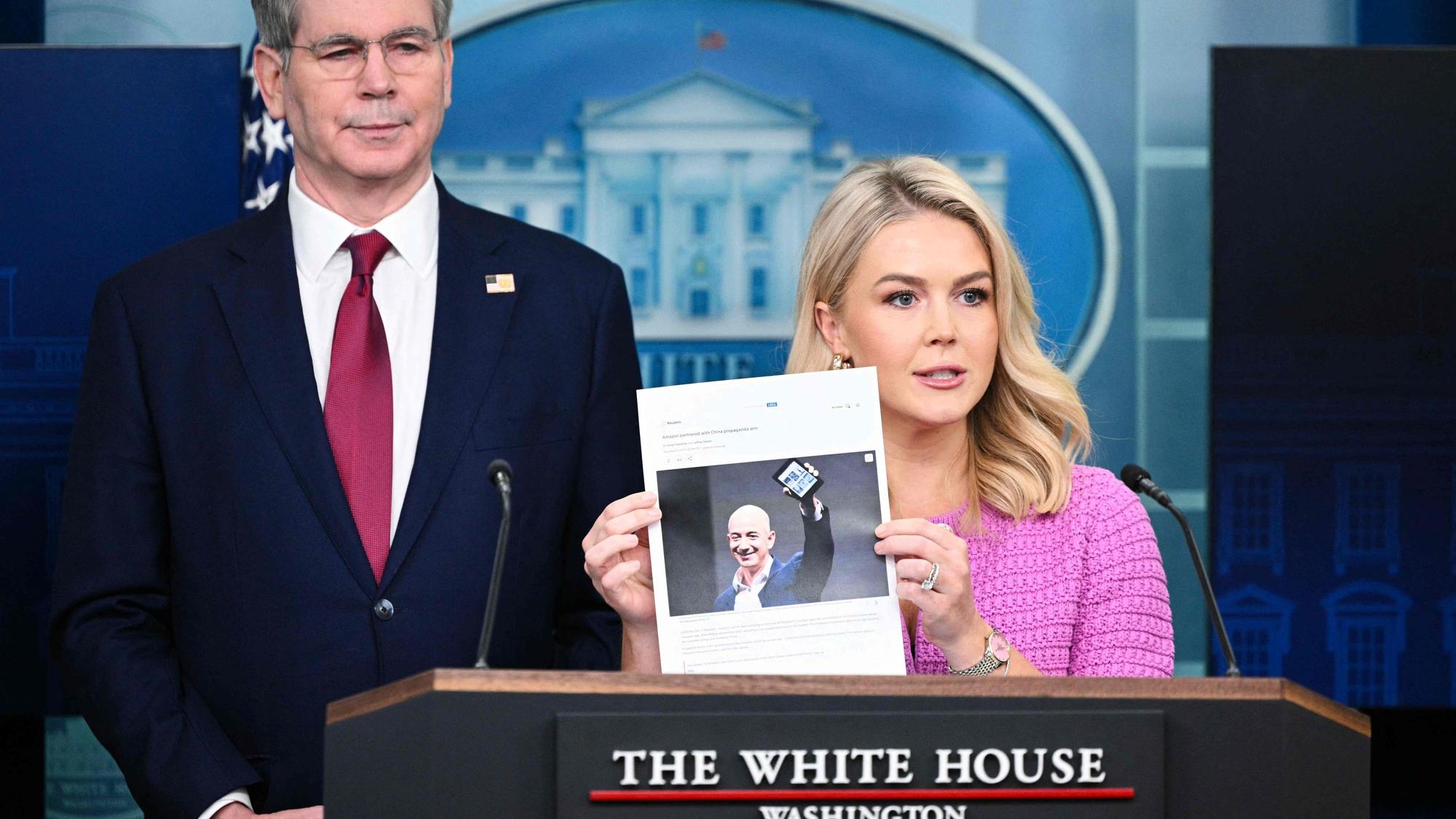 Sprecherin Karoline Leavitt hält einen Artikel der Nachrichtenagentur Reuters von Ende 2021 mit einem Bild von Konzernchef Bezos in die Höhe.
