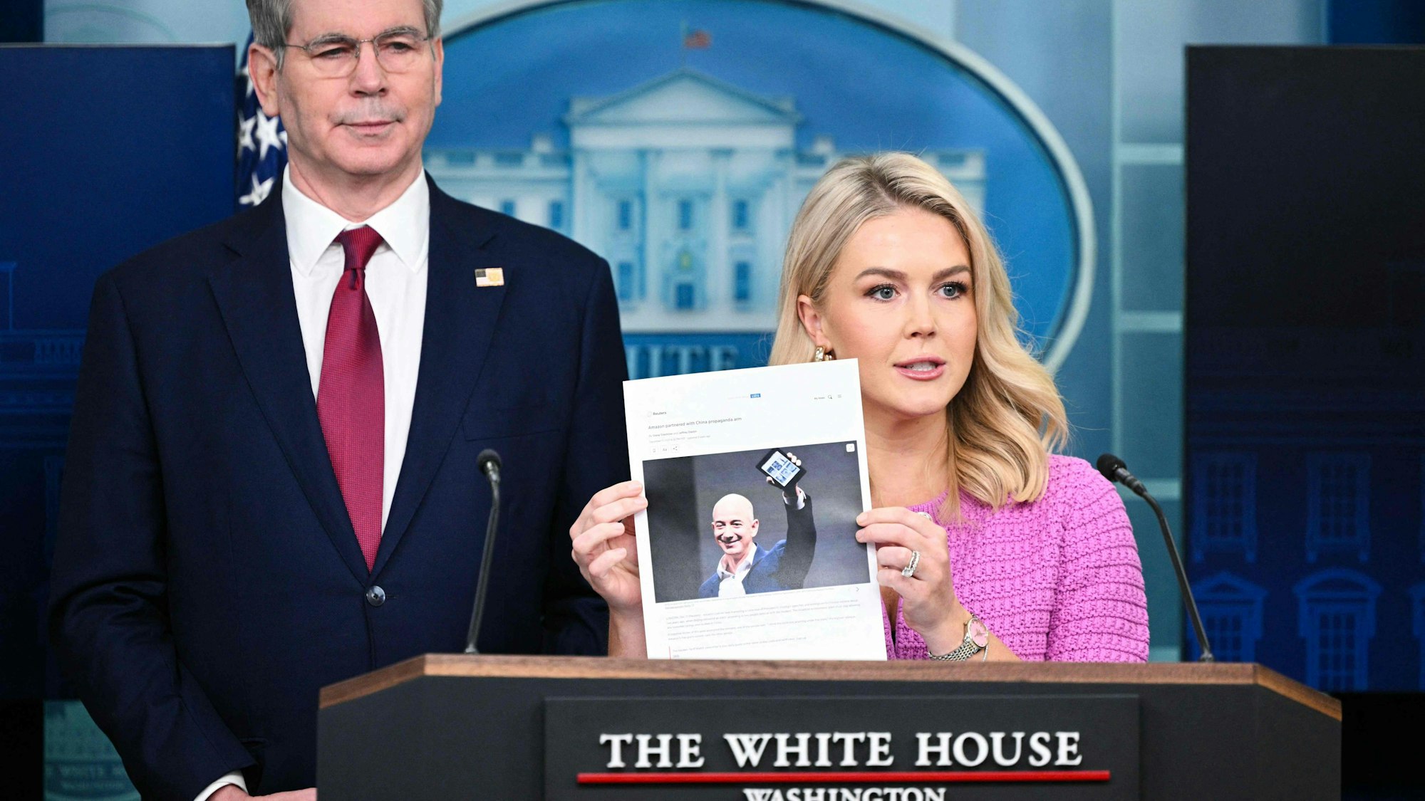 Sprecherin Karoline Leavitt hält einen Artikel der Nachrichtenagentur Reuters von Ende 2021 mit einem Bild von Konzernchef Bezos in die Höhe.