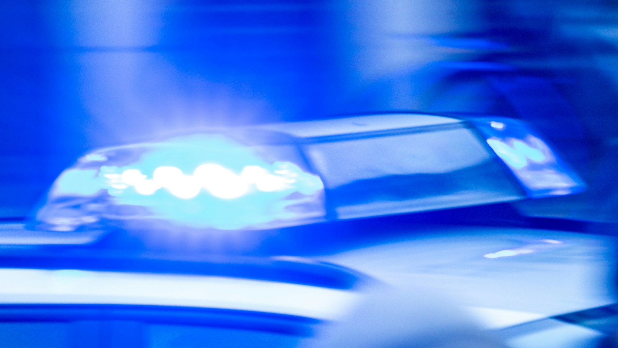 Ein Streifenwagen der Polizei ist mit Blaulicht im Einsatz.