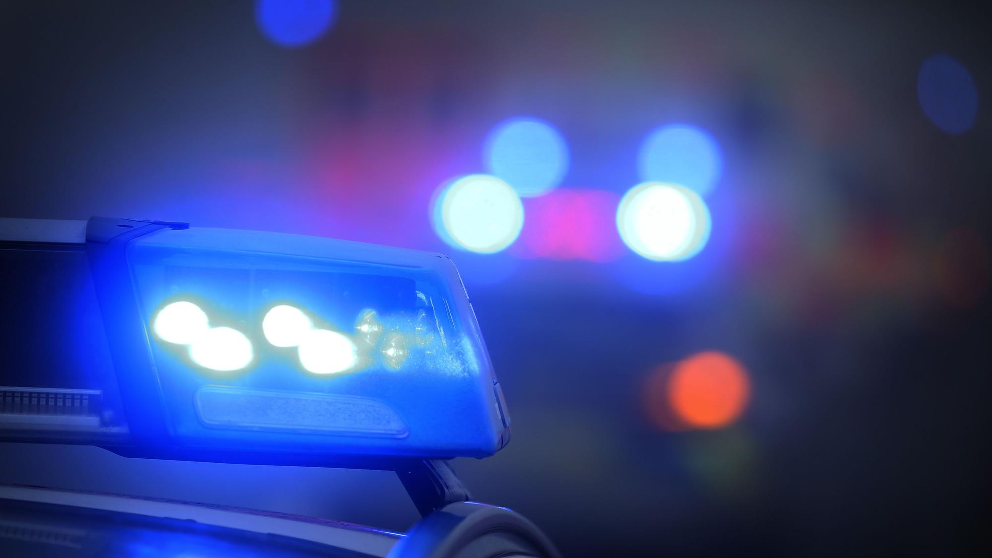 Ein Polizeiauto mit eingeschaltetem Blaulicht steht an einem Tatort (Symbolfoto).