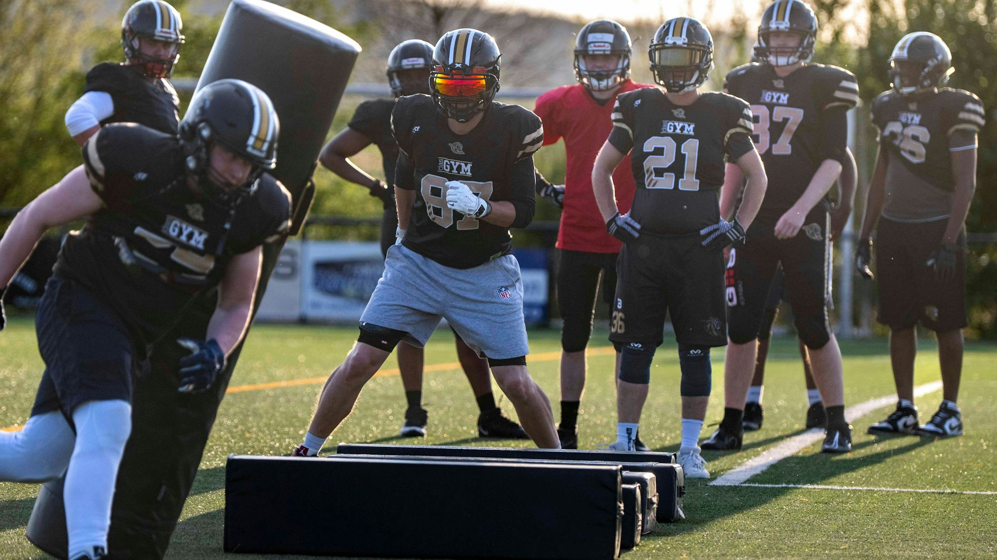 Footballer der Euskirchen Lions laufen beim Training um Hindernisse herum.